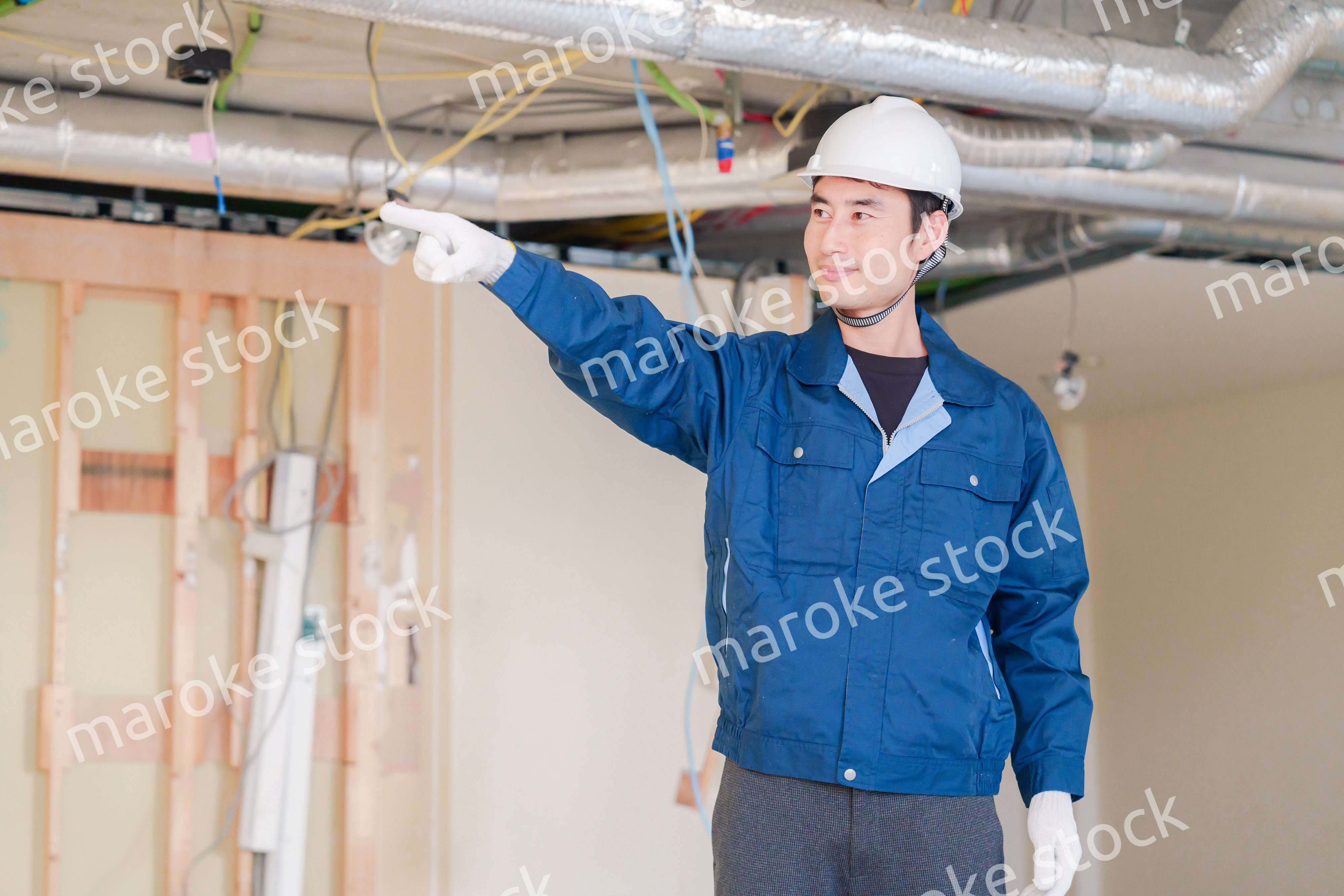 指差しをして安全確認をする男性の建築作業員