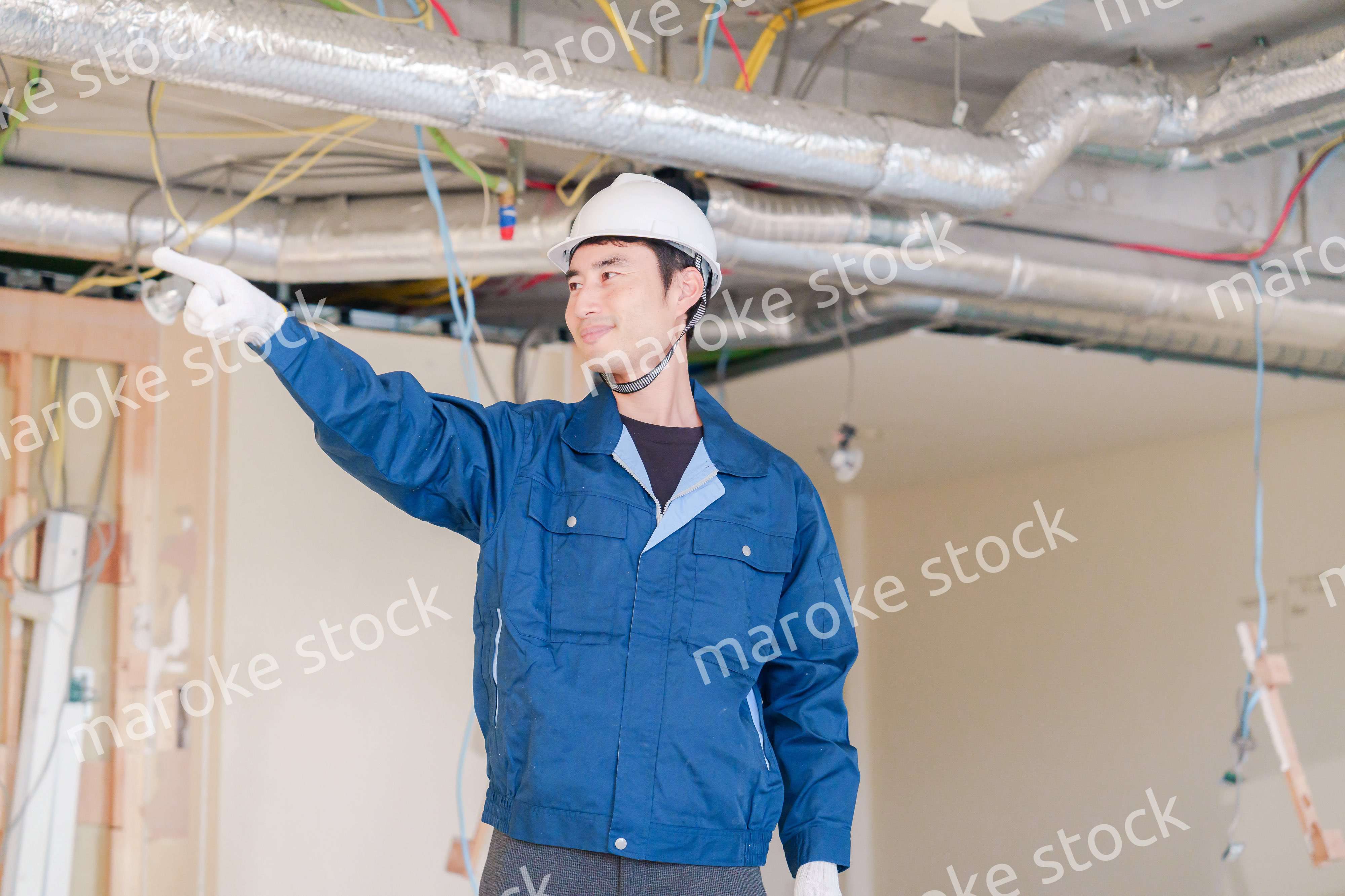 指差しをして安全確認をする男性の建築作業員