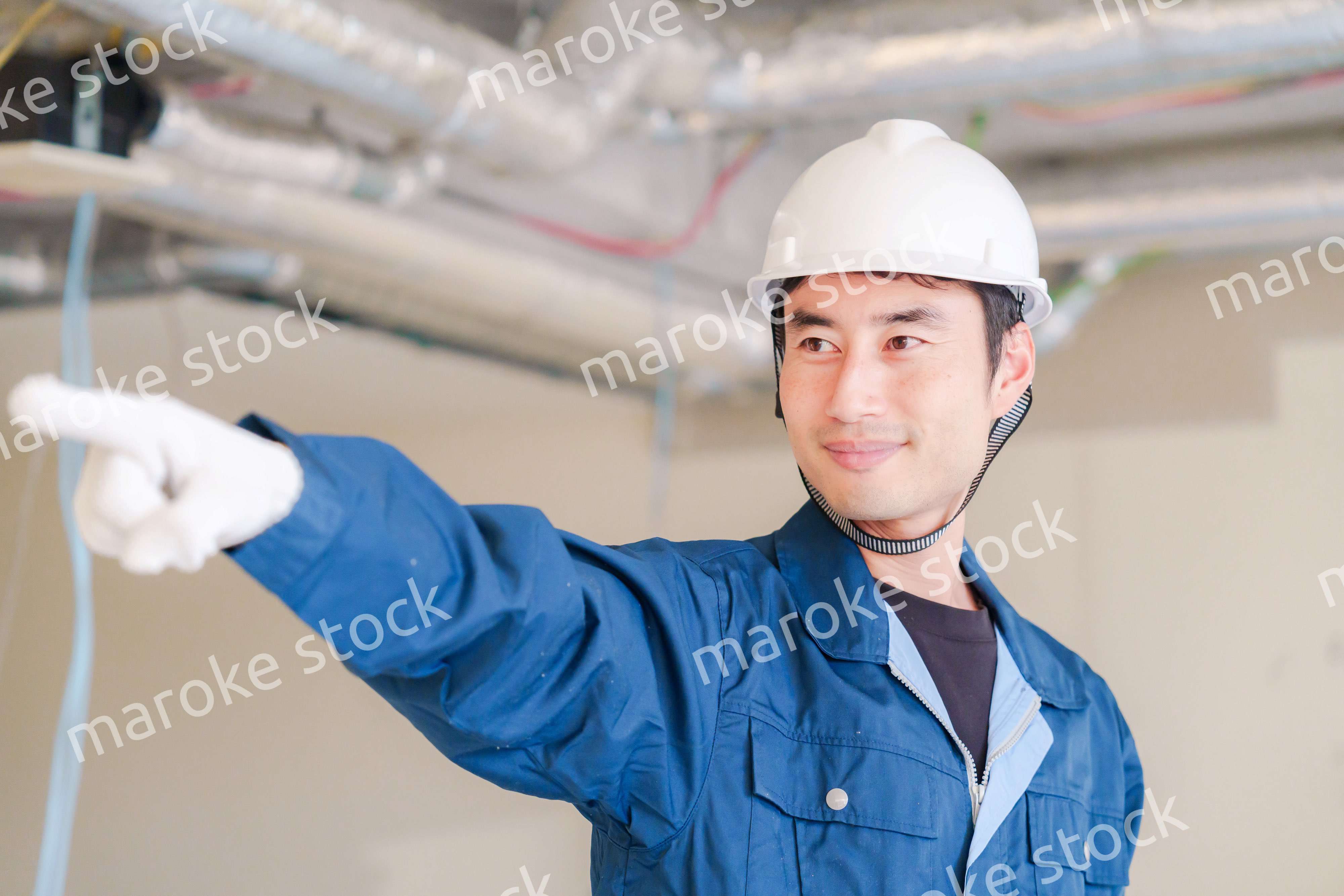 指差しをして安全確認をする男性の建築作業員