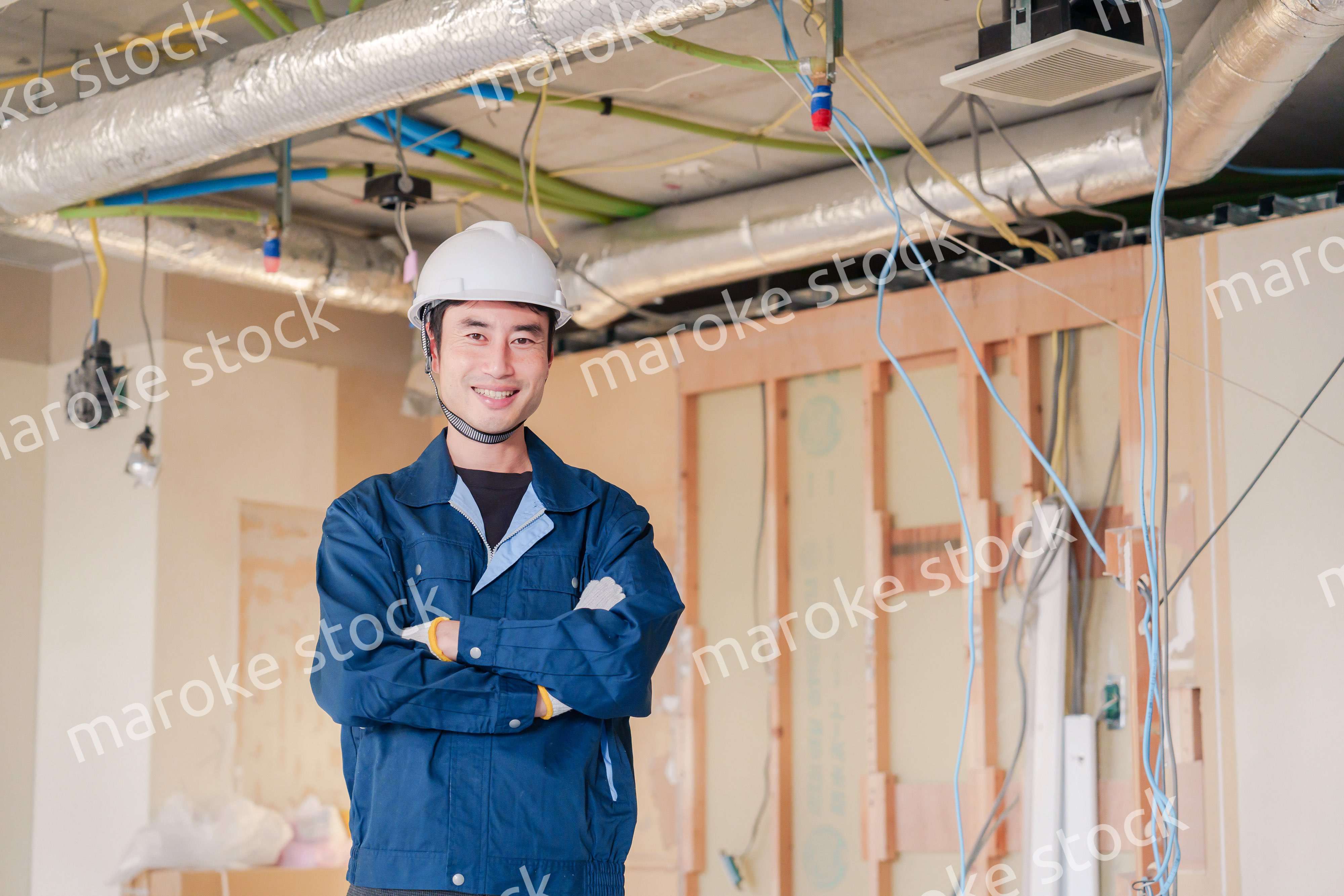 工事現場で腕を組む男性の職人