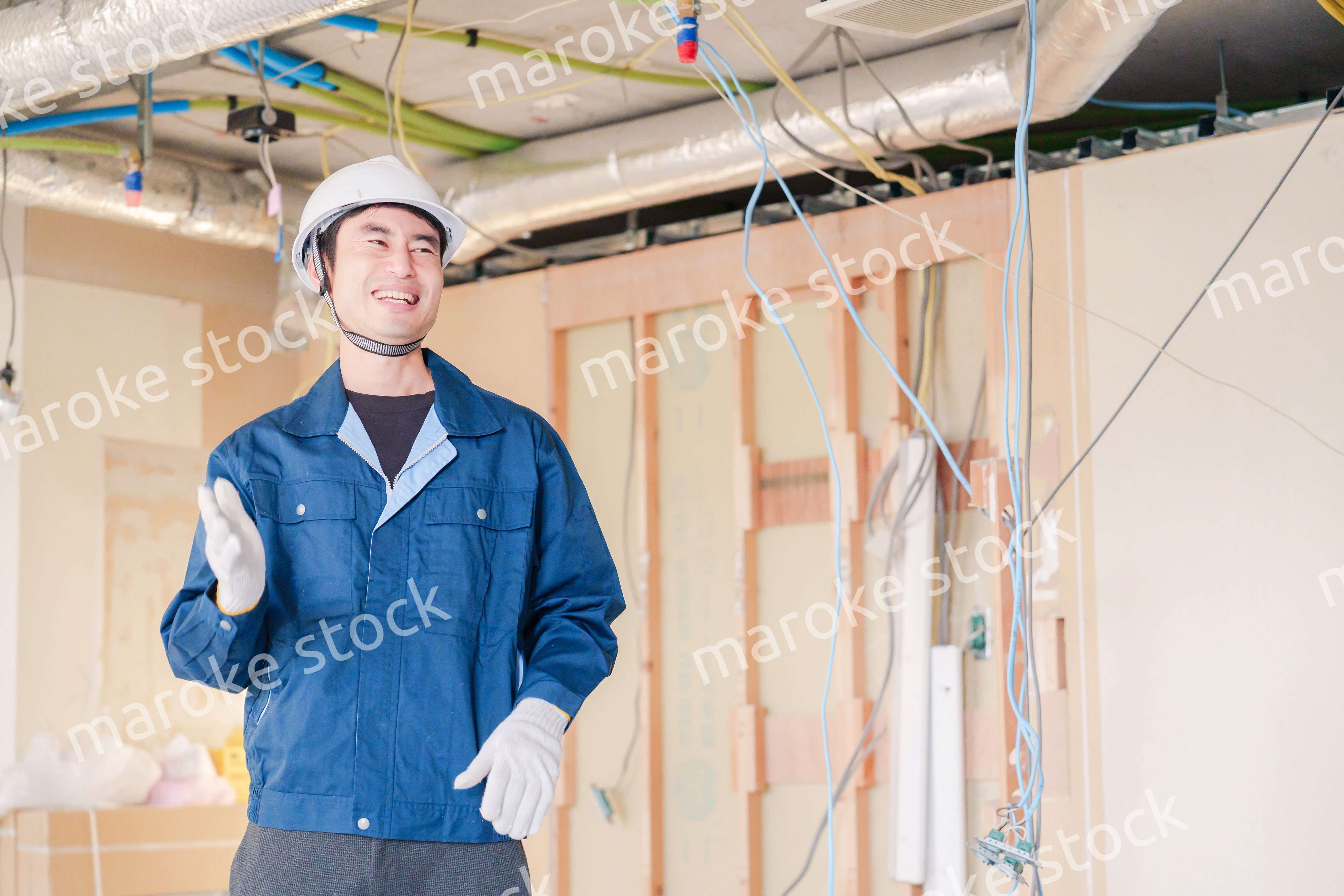 工事現場で楽しく働く職人の男性