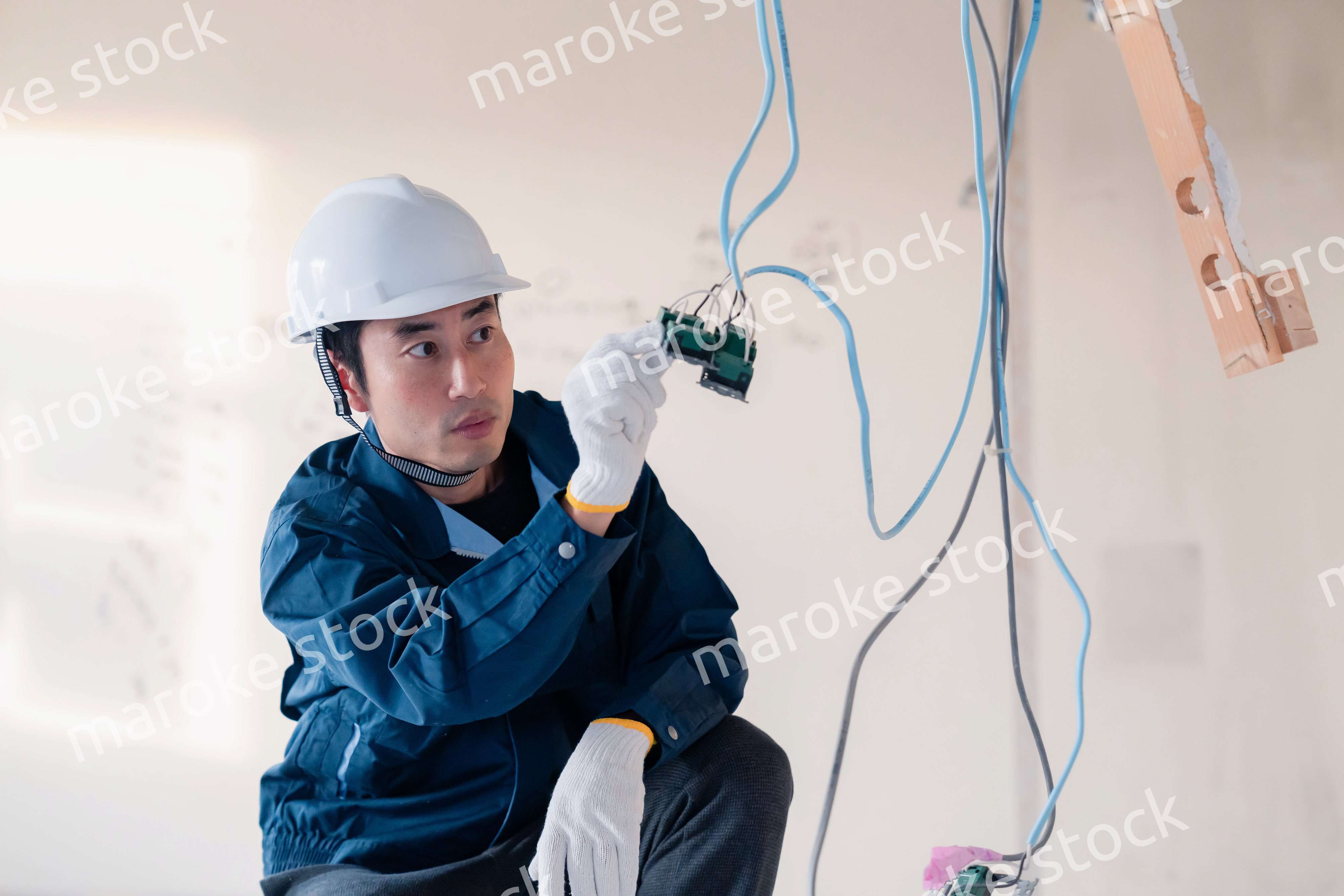 建築現場で配線工事をする電気工事士