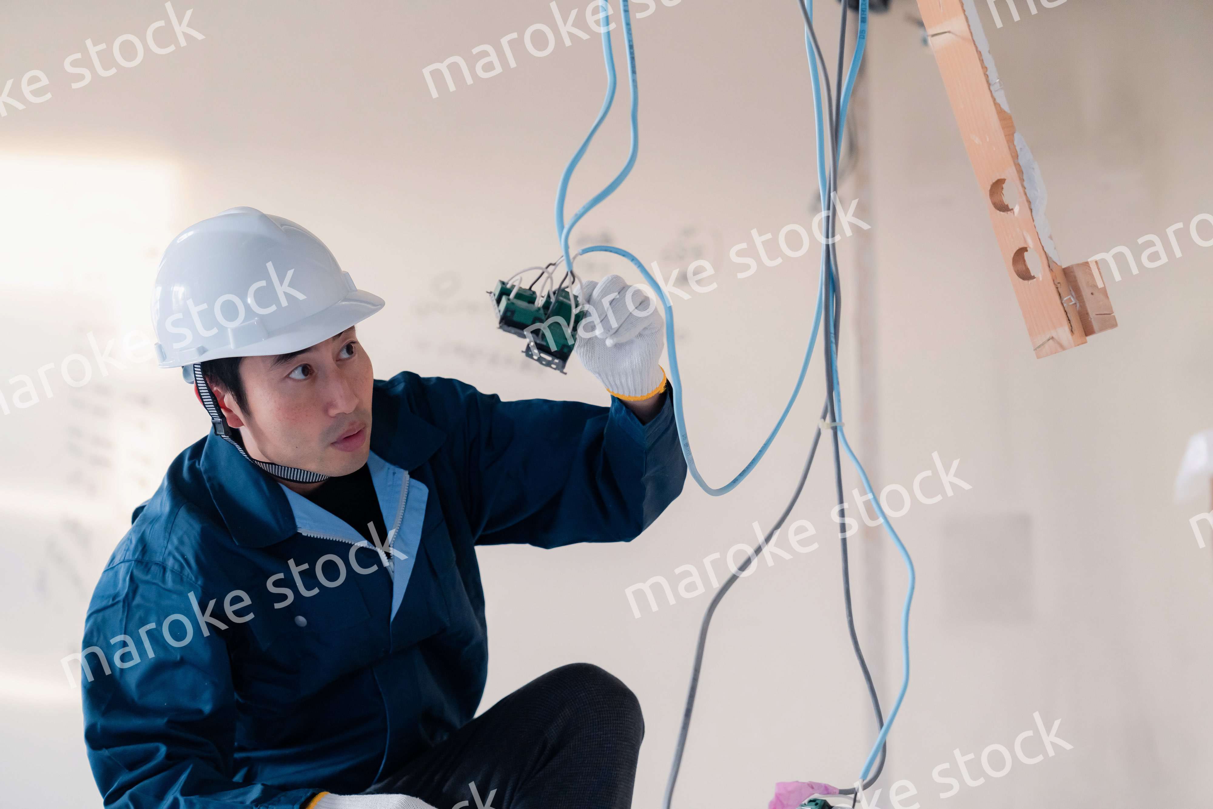 建築現場で配線工事をする電気工事士