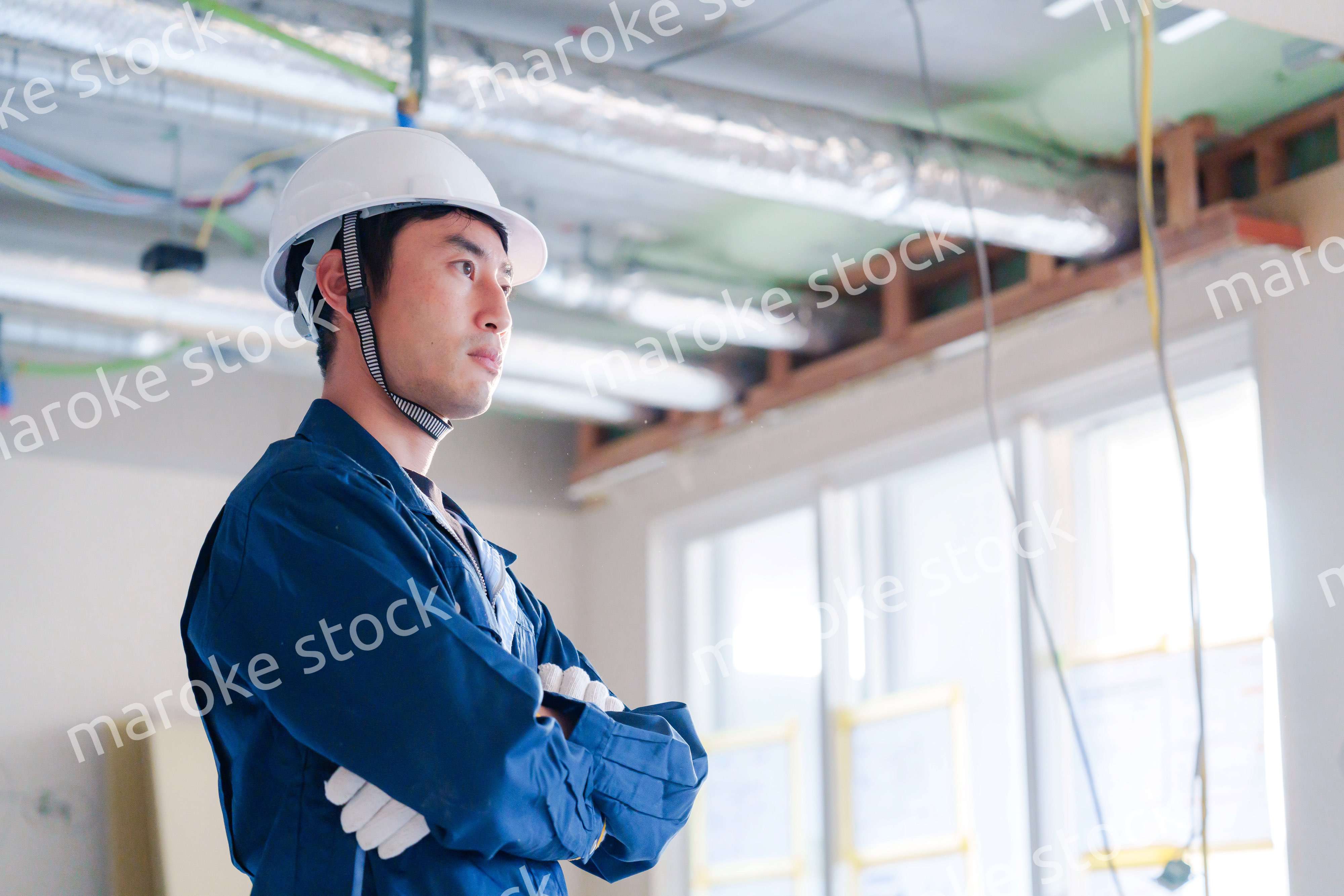 工事現場で腕を組む男性の職人