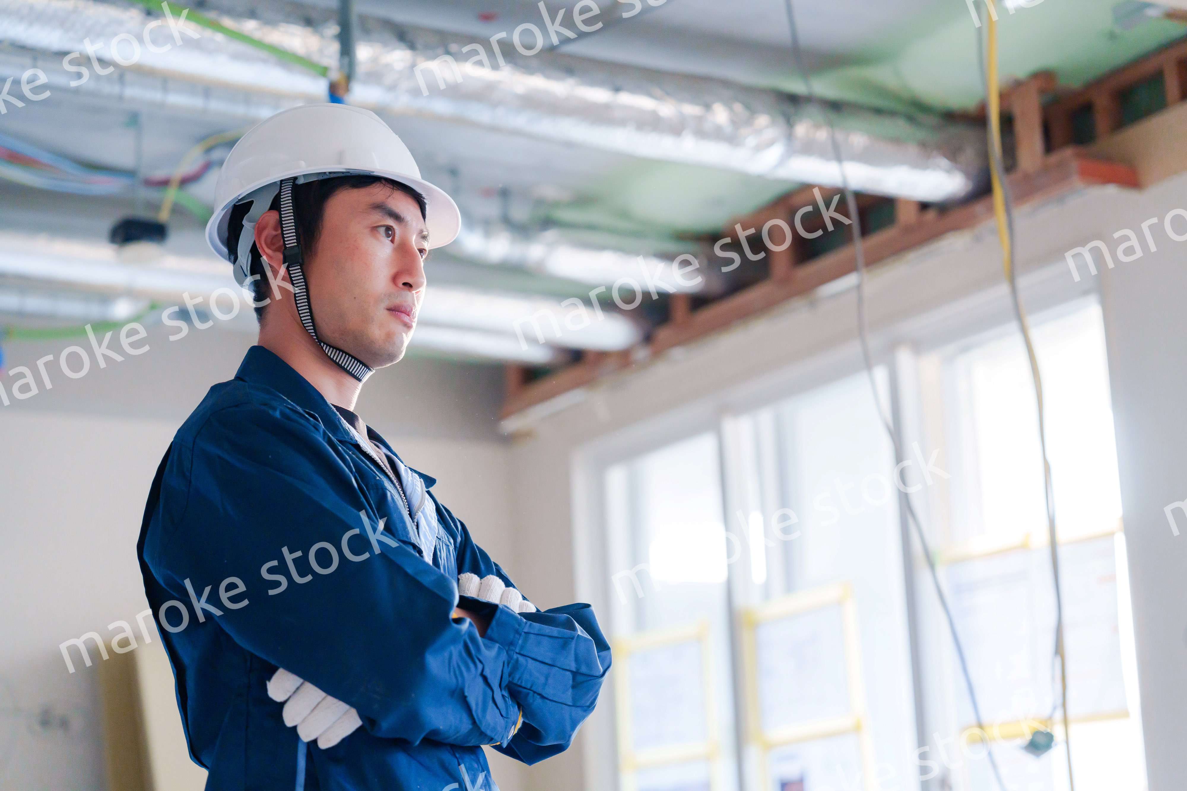 工事現場で腕を組む男性の職人