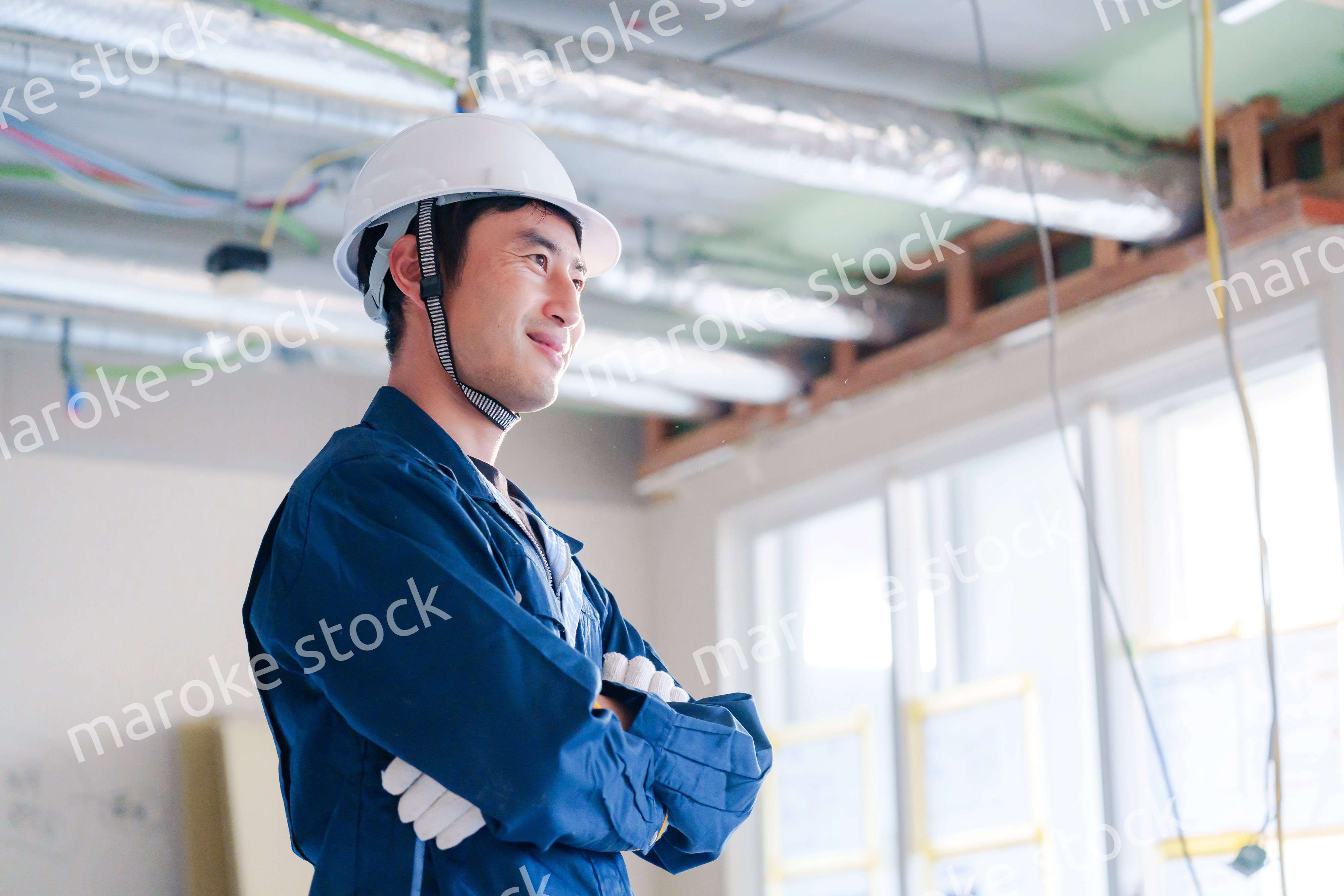 工事現場で腕を組む男性の職人