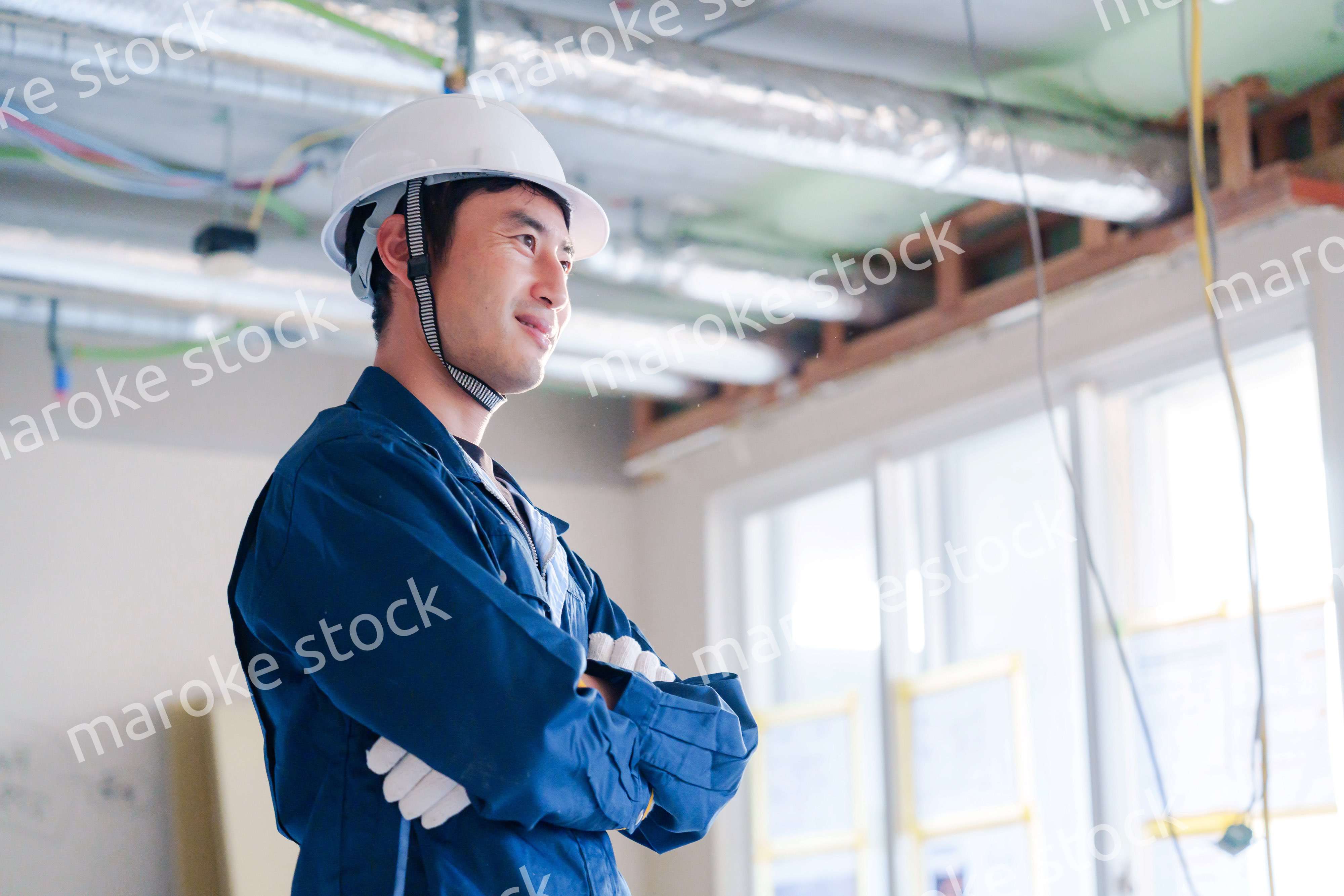 工事現場で腕を組む男性の職人