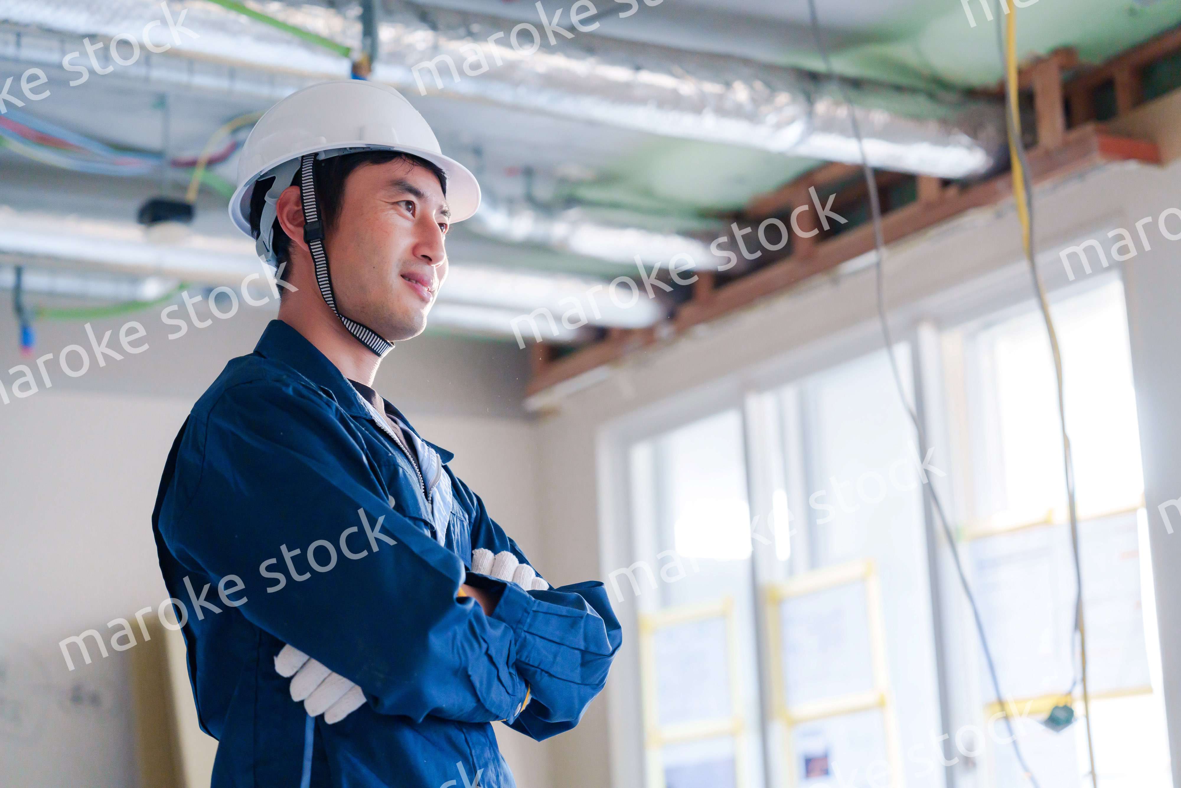 工事現場で腕を組む男性の職人