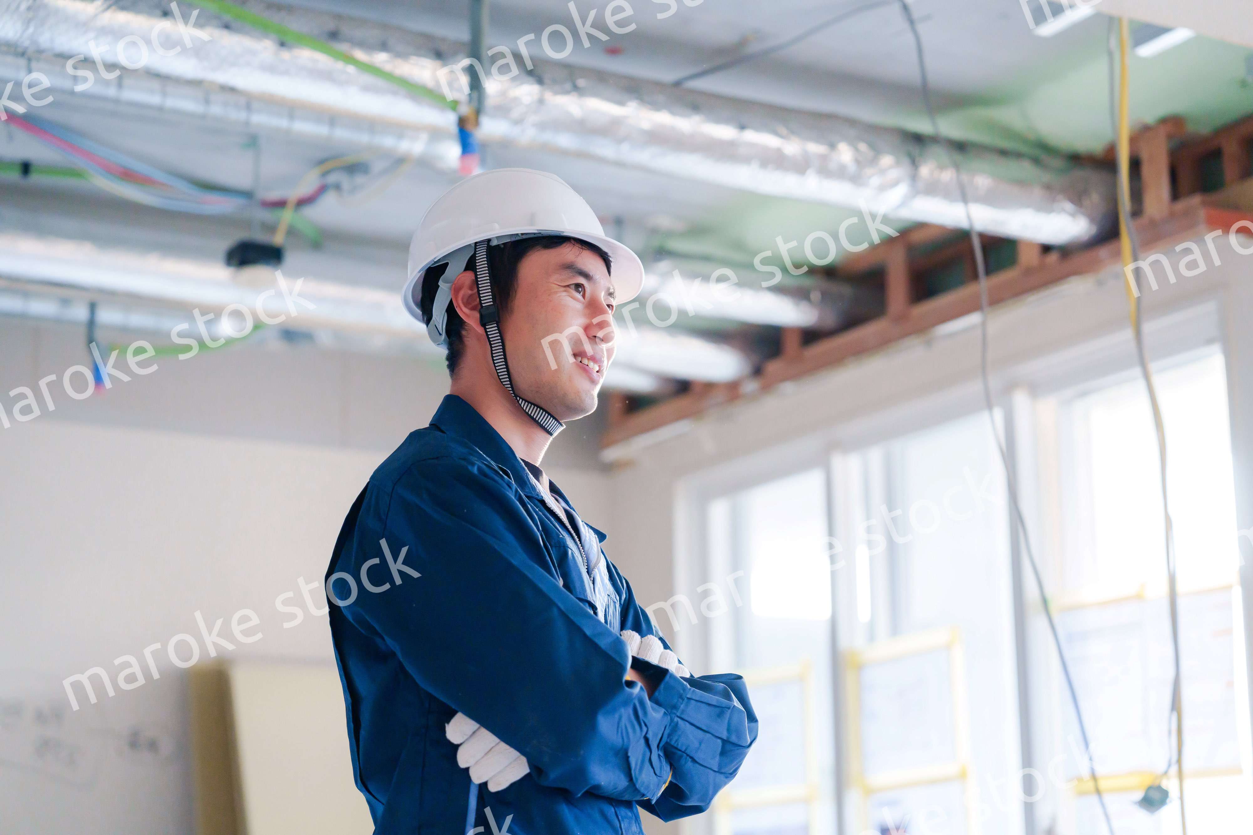 工事現場で腕を組む男性の職人