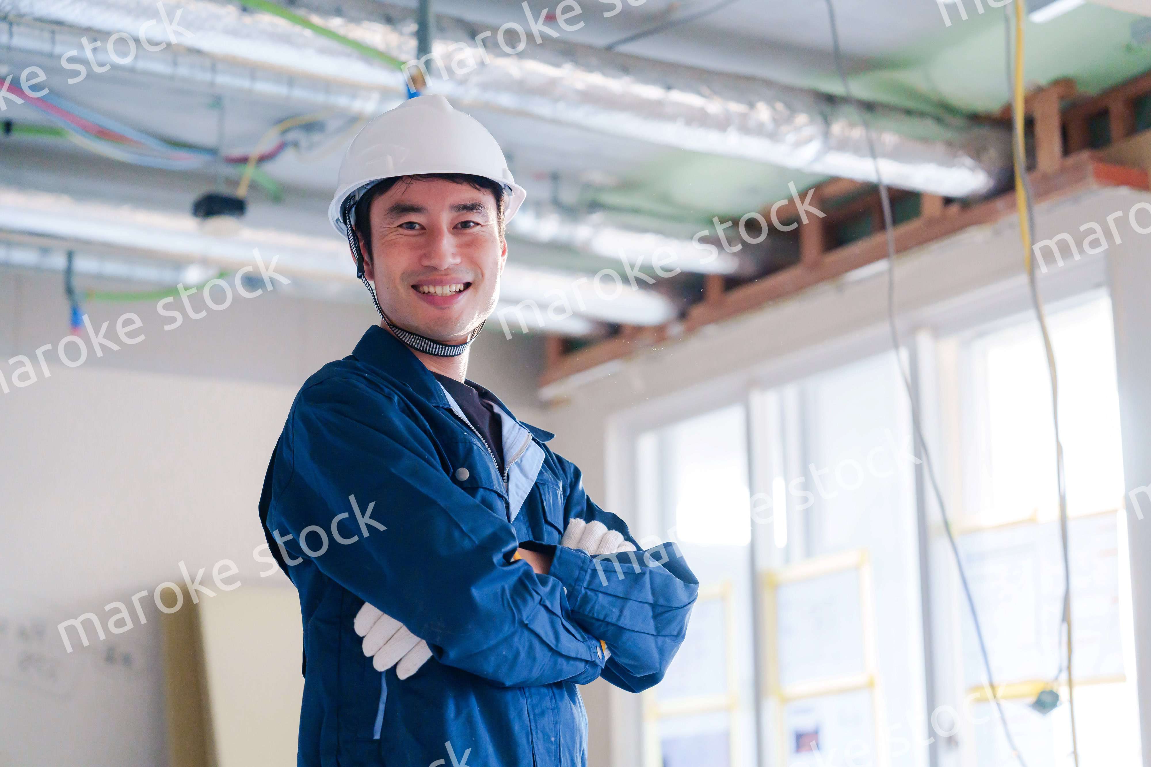 工事現場で腕を組む男性の職人