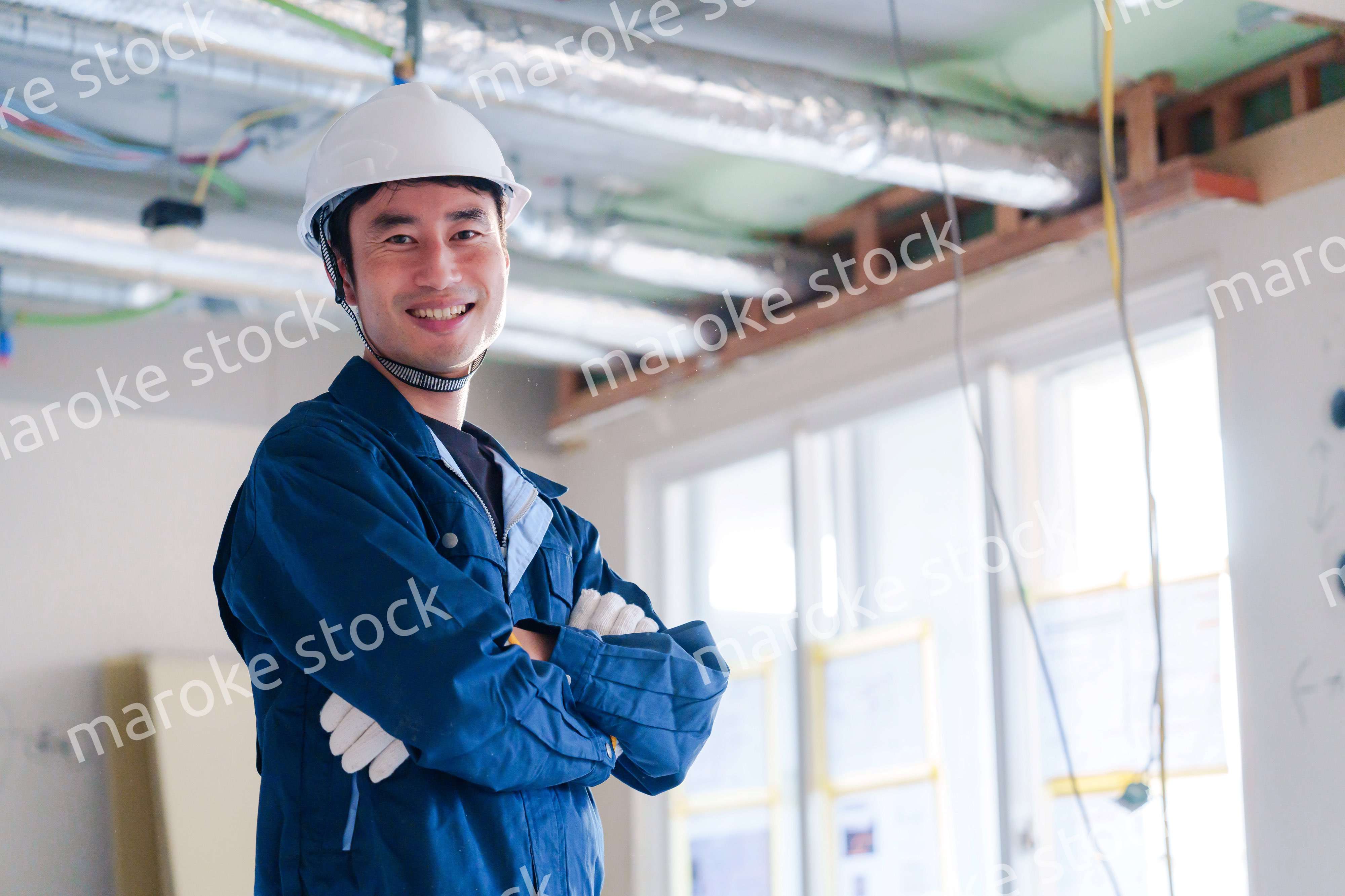 工事現場で腕を組む男性の職人