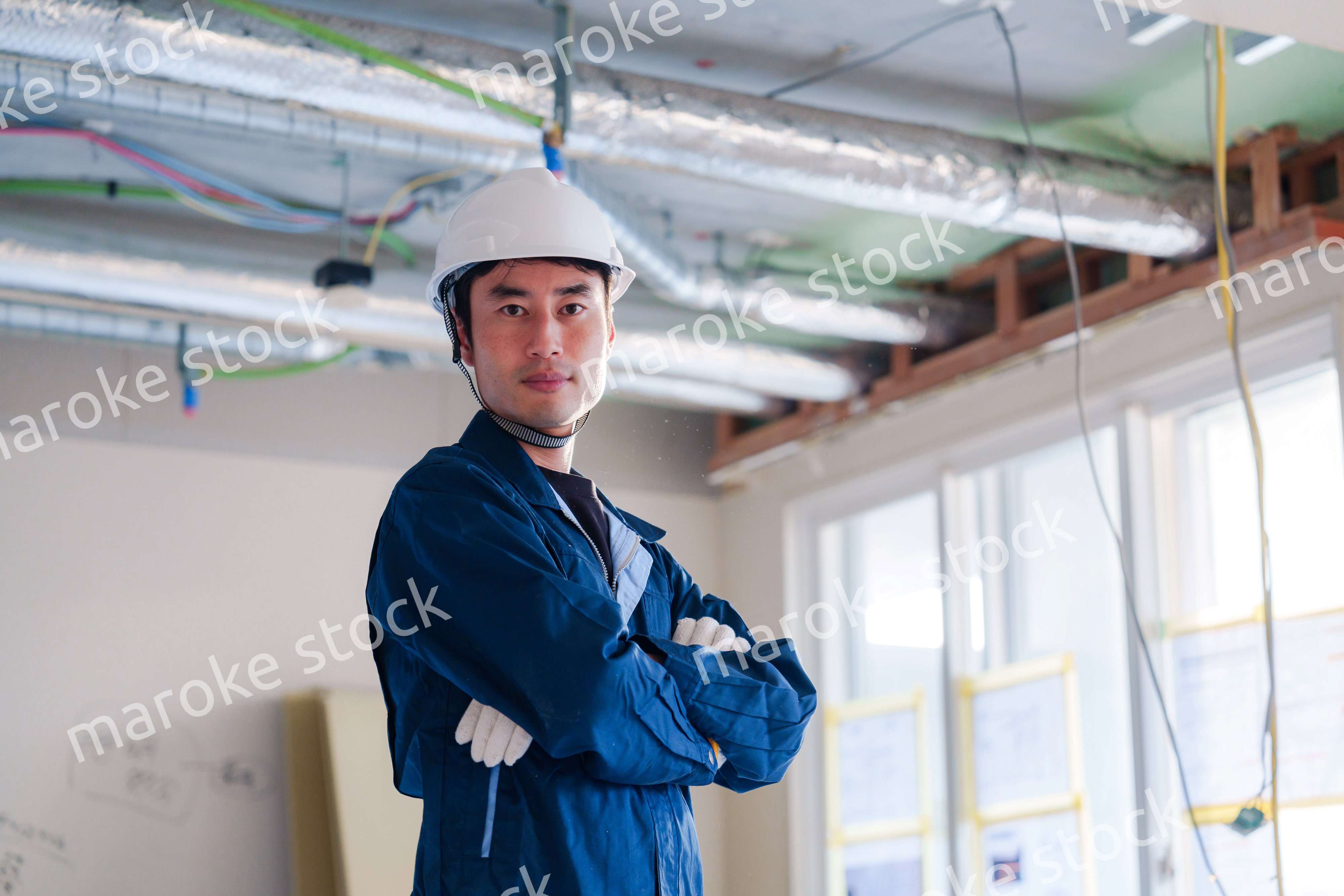 工事現場で腕を組む男性の職人