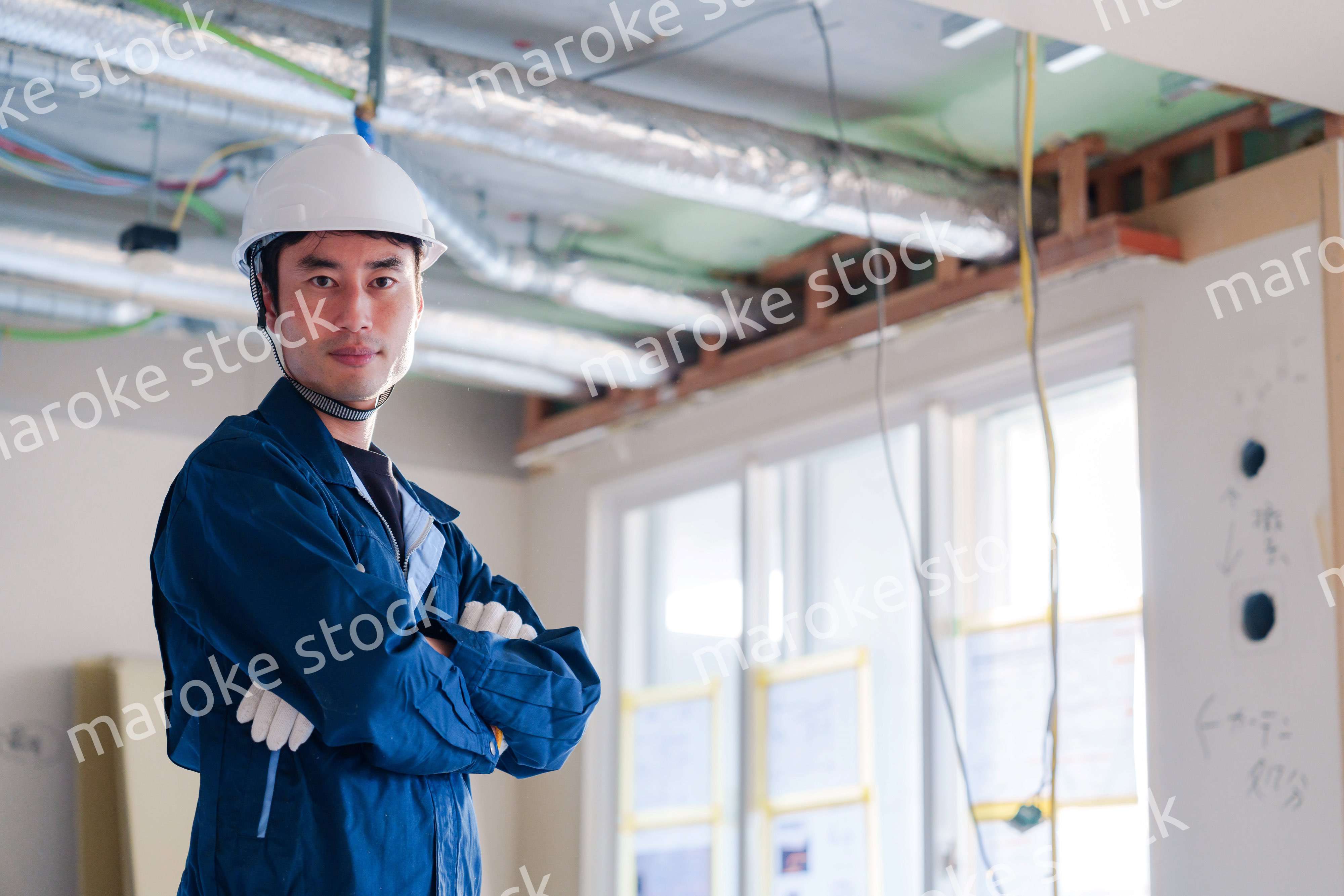 工事現場で腕を組む男性の職人