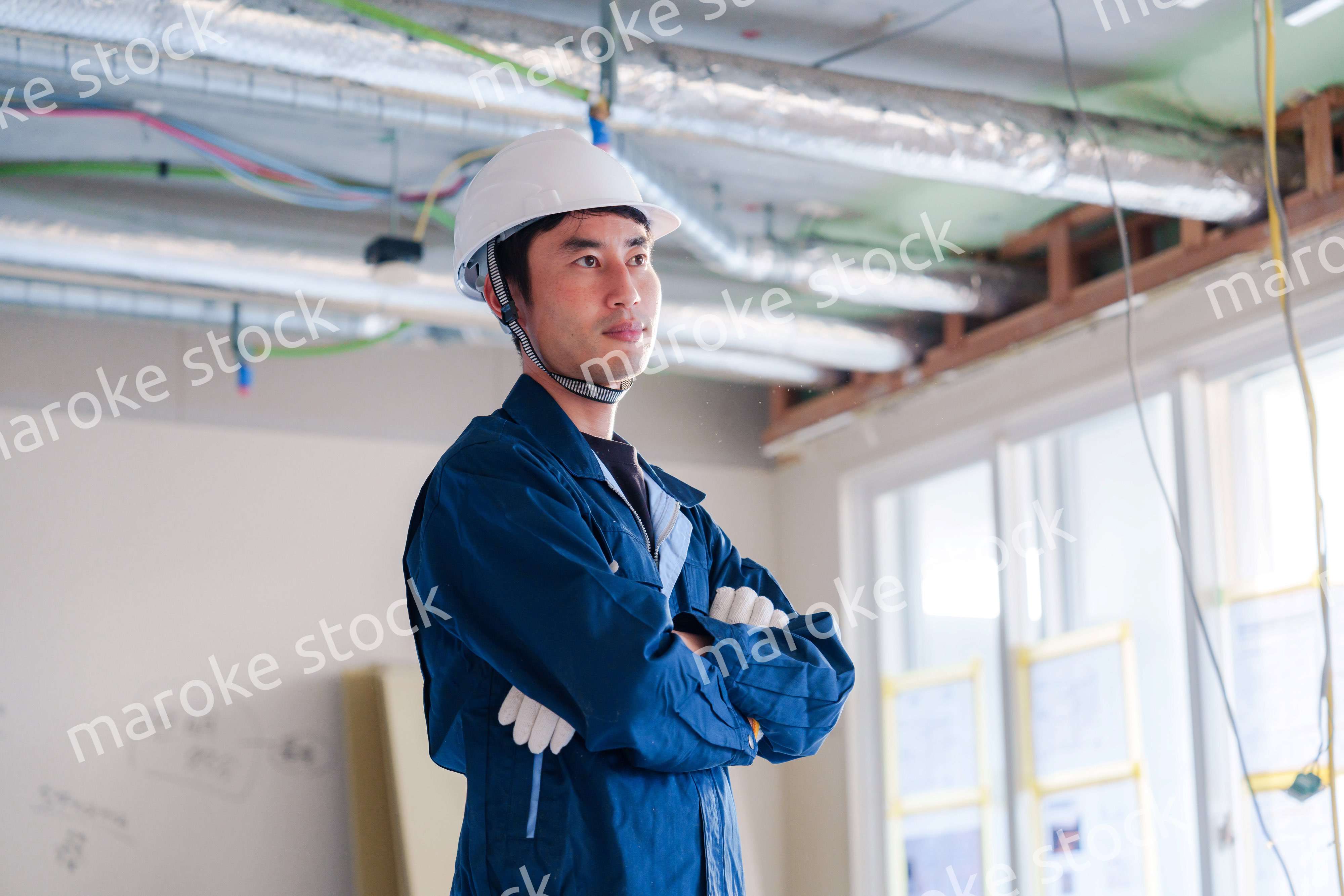 工事現場で腕を組む男性の職人