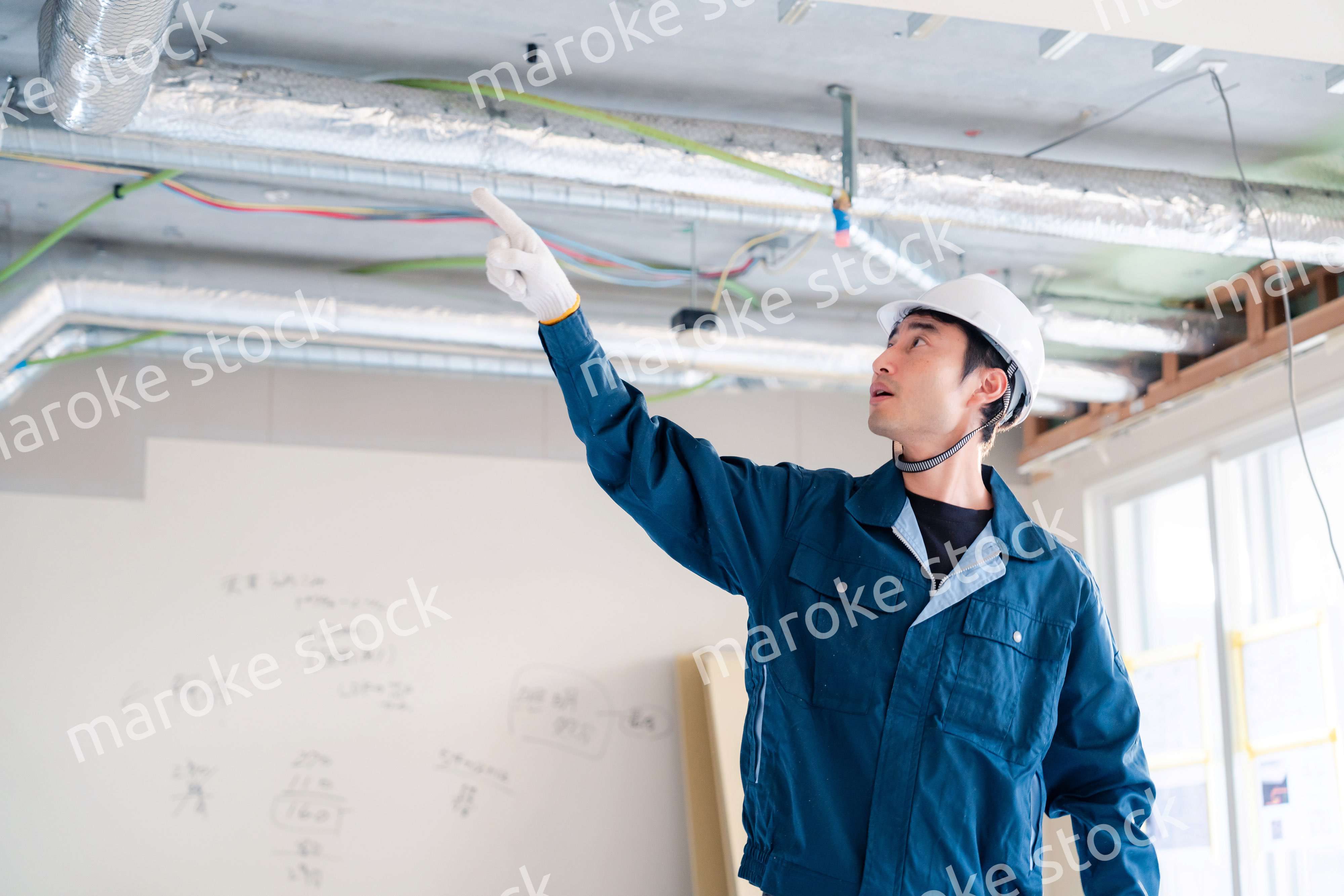 指差しをして安全確認をする男性の建築作業員