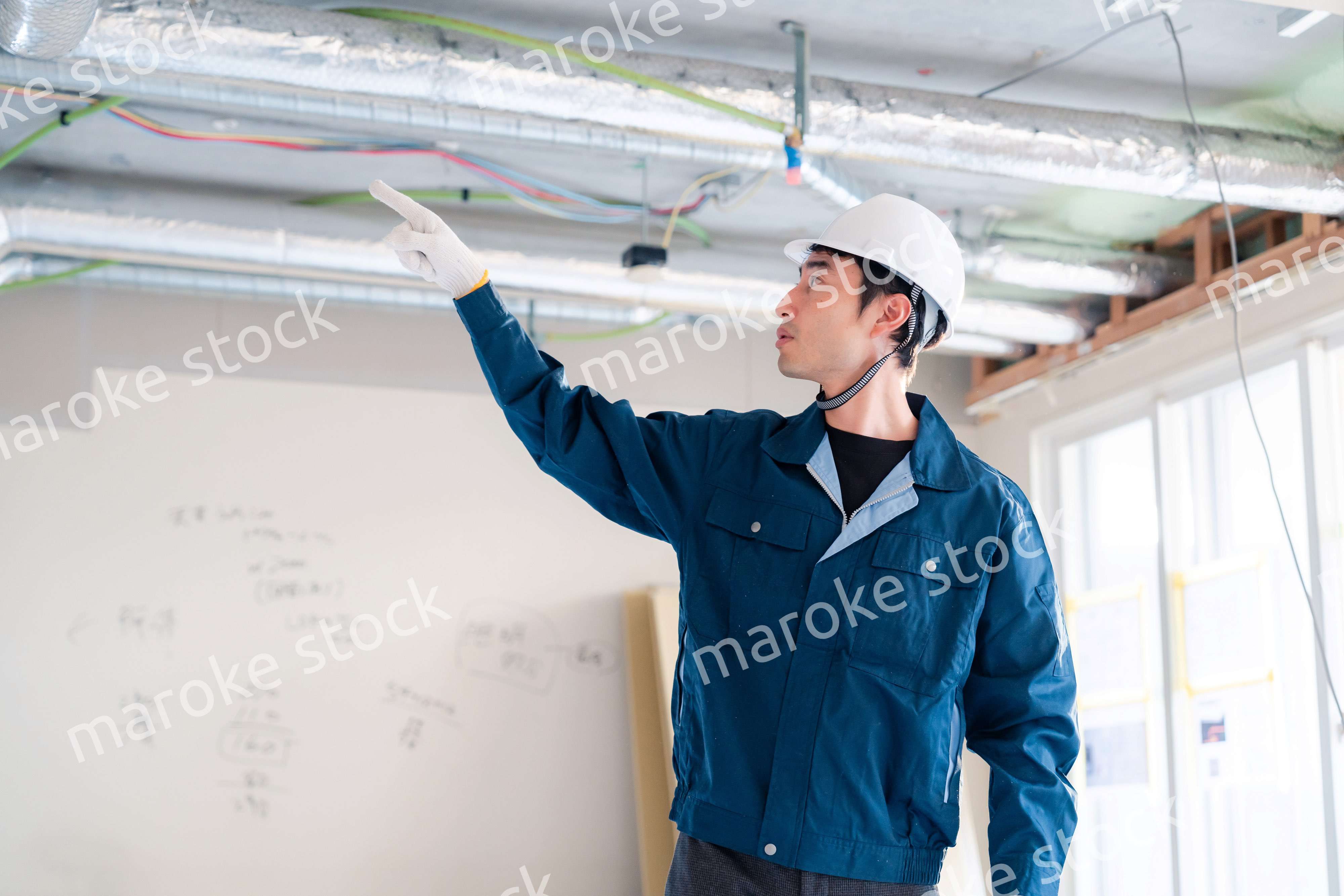 指差しをして安全確認をする男性の建築作業員