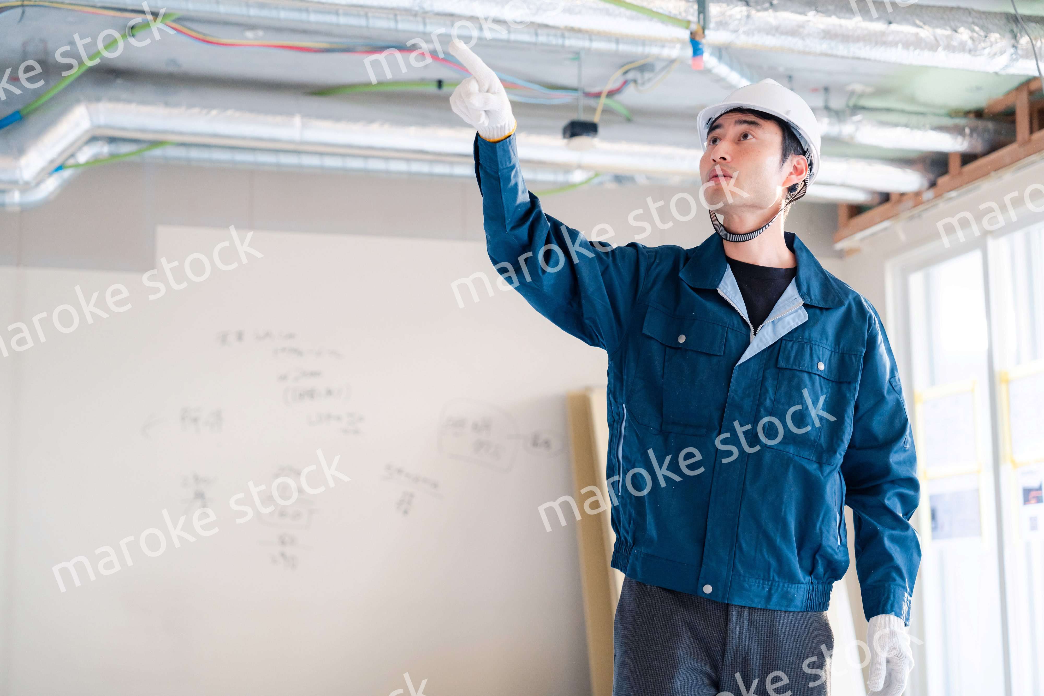 指差しをして安全確認をする男性の建築作業員