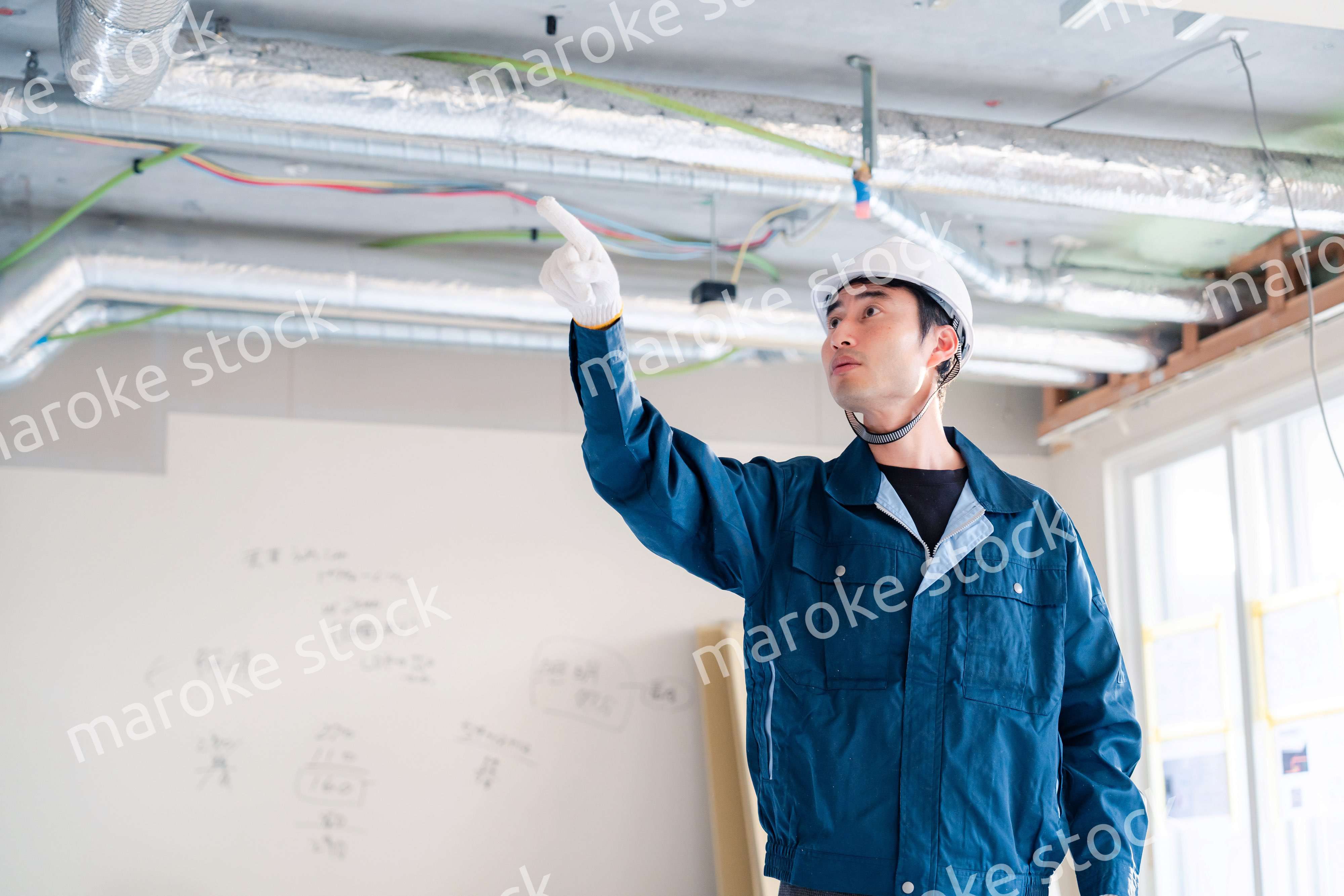 指差しをして安全確認をする男性の建築作業員