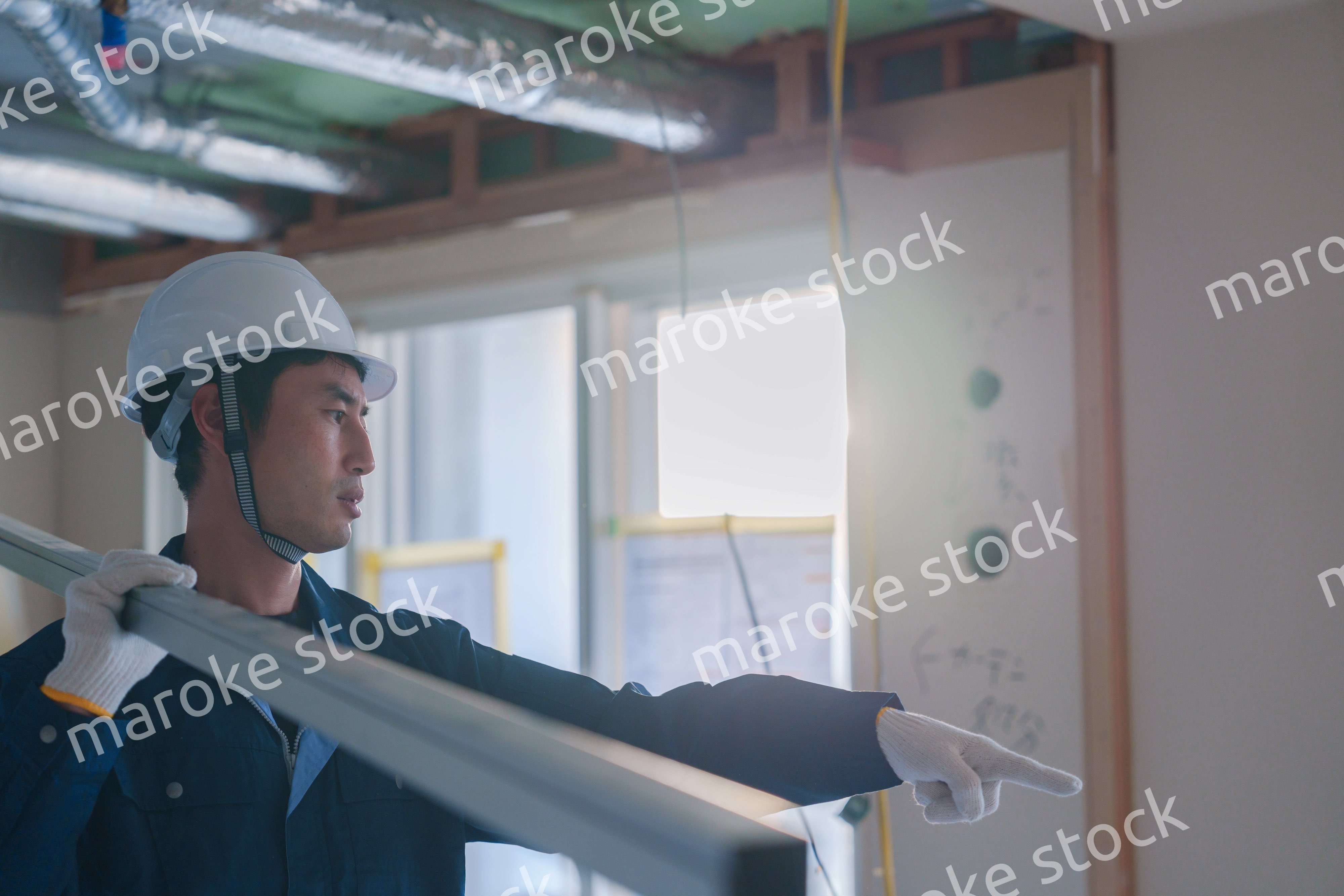 建設現場で資材を運ぶ男性の職人