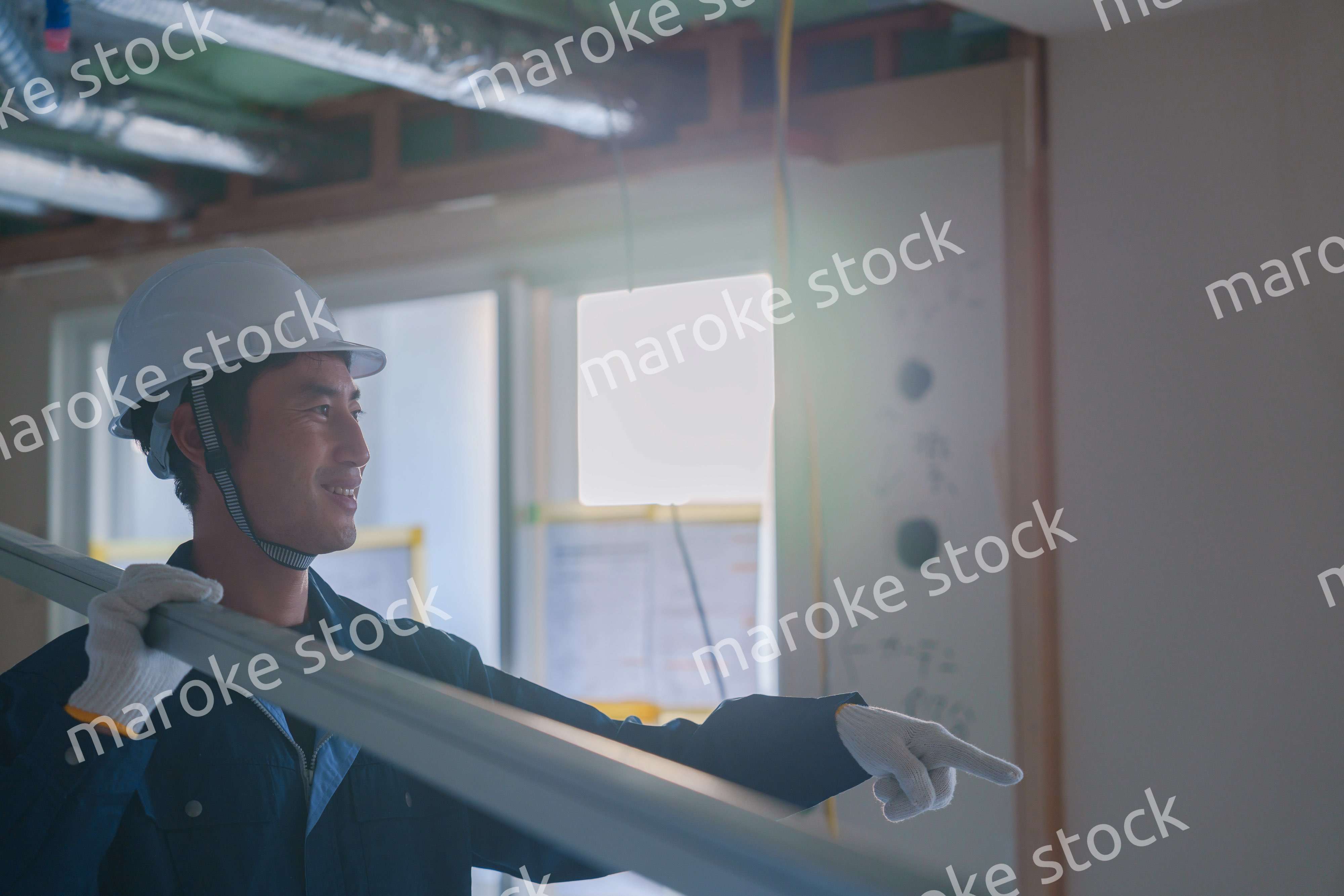 建設現場で資材を運ぶ男性の職人