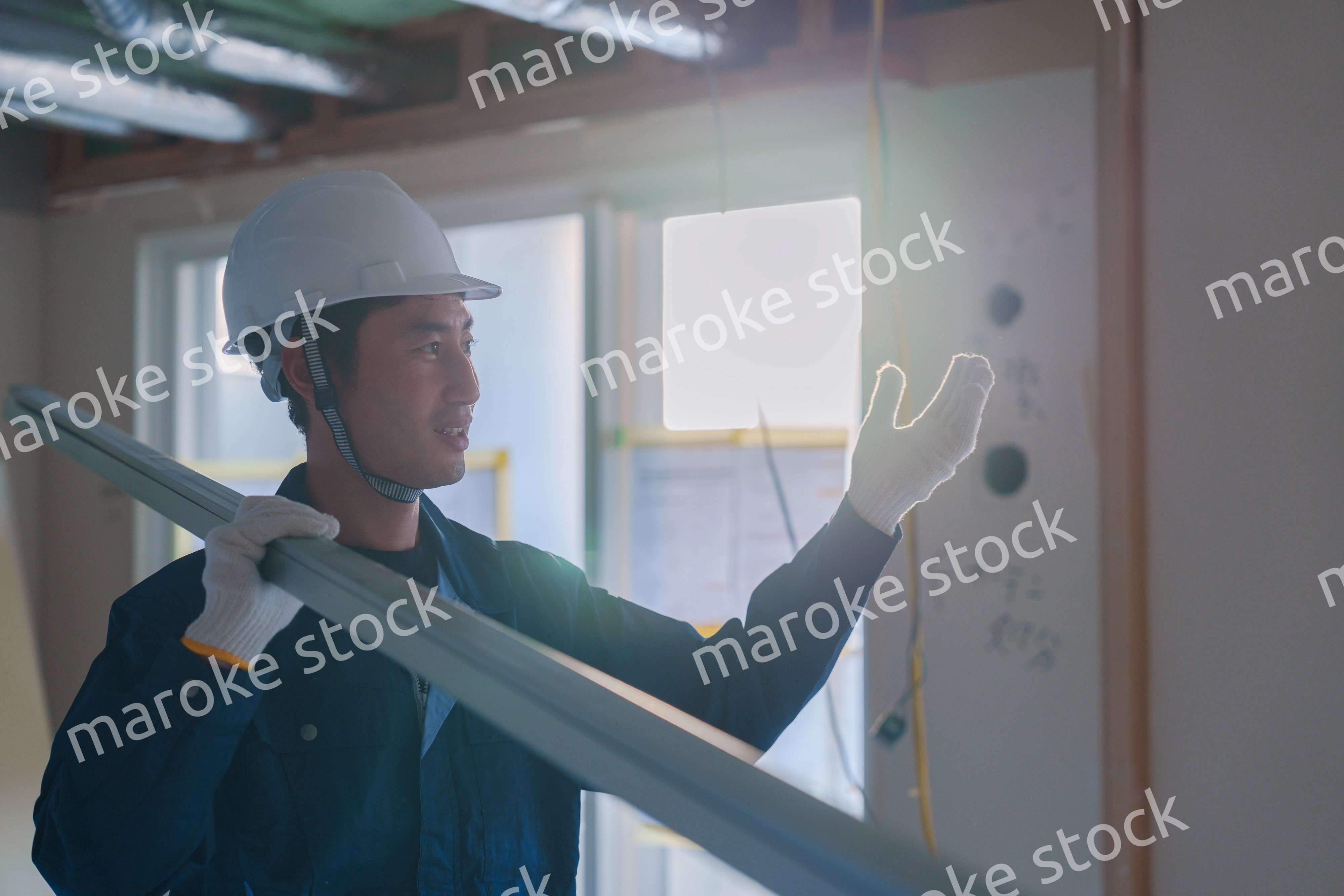 建設現場で資材を運ぶ男性の職人