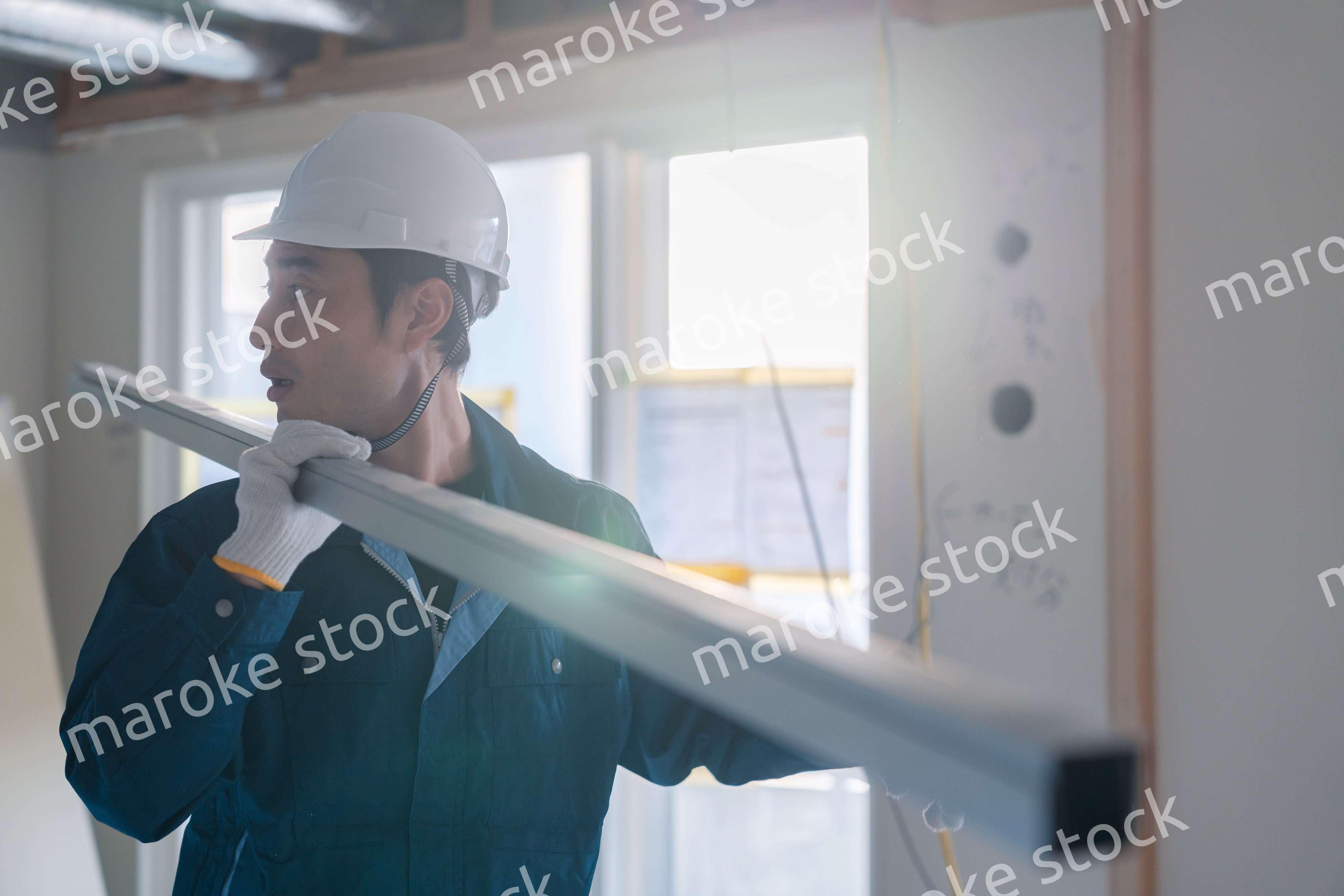 建設現場で資材を運ぶ男性の職人