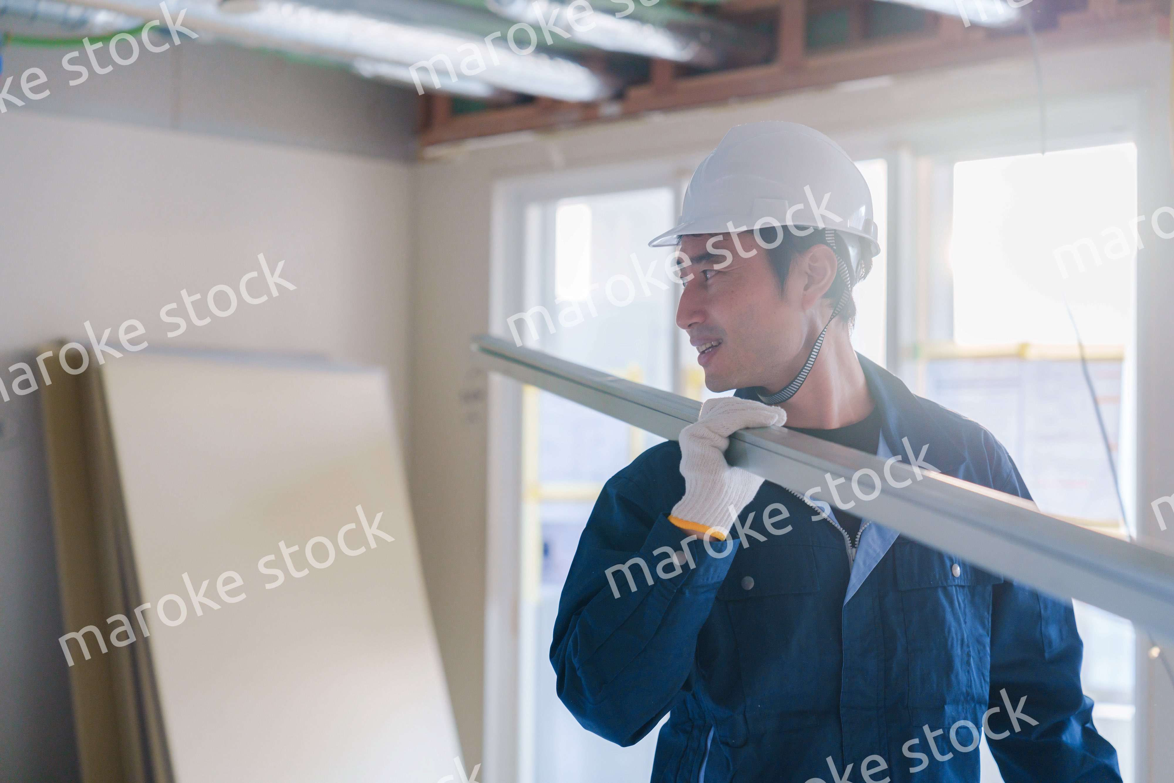 建設現場で資材を運ぶ男性の職人