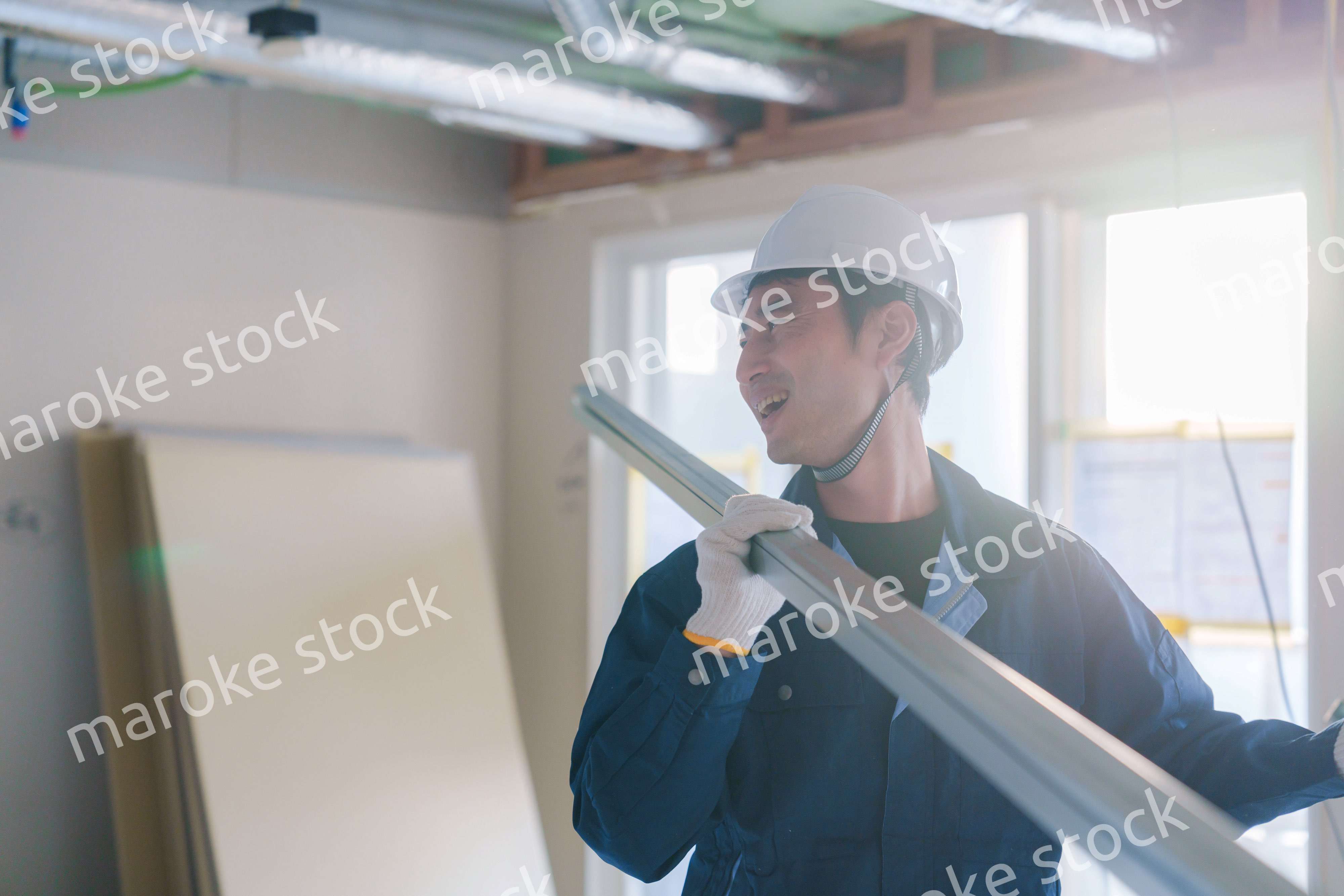 建設現場で資材を運ぶ男性の職人