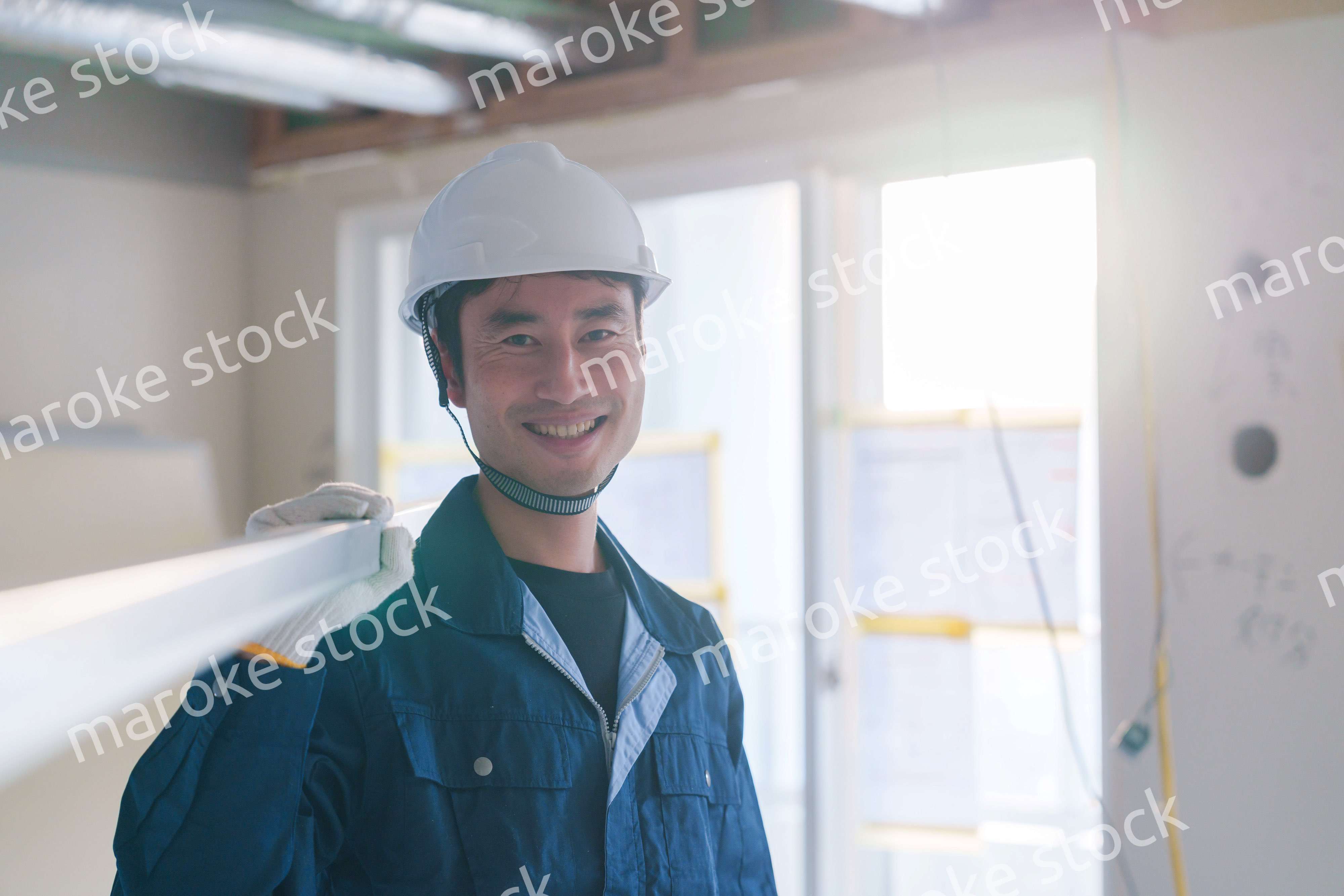 建設現場で資材を運ぶ男性の職人