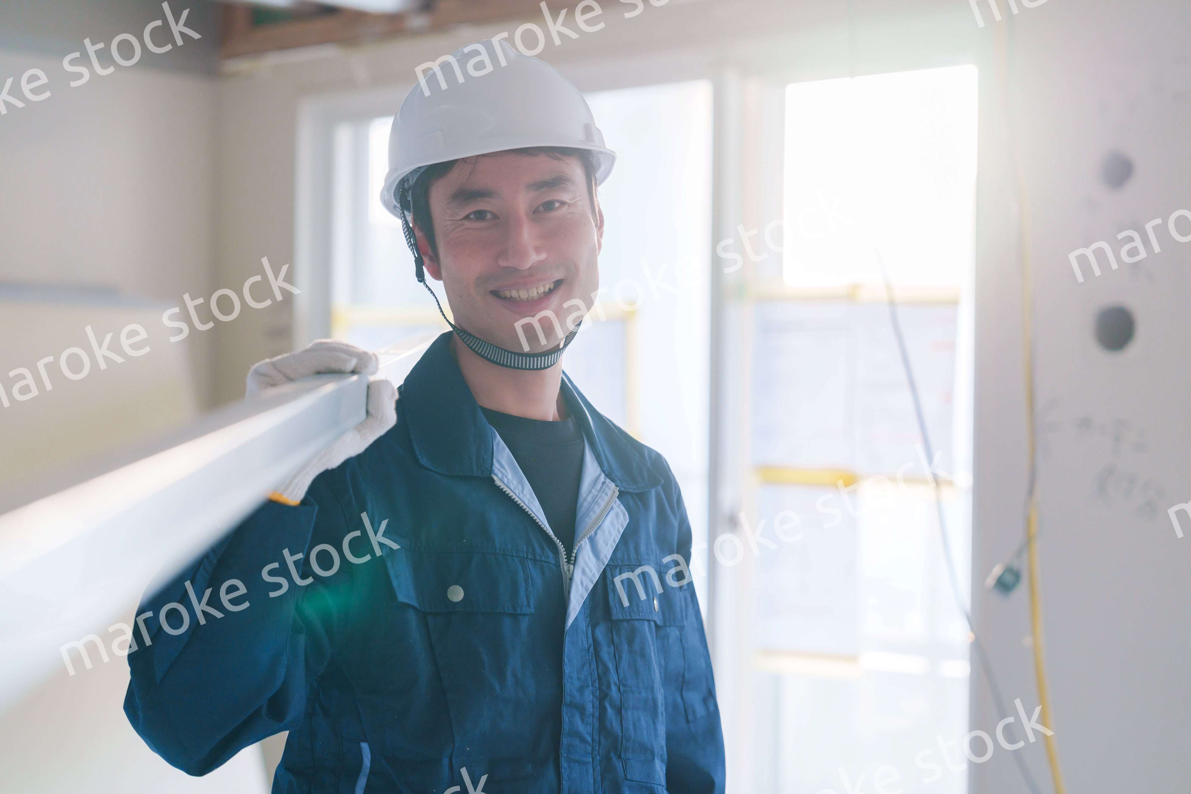 建設現場で資材を運ぶ男性の職人