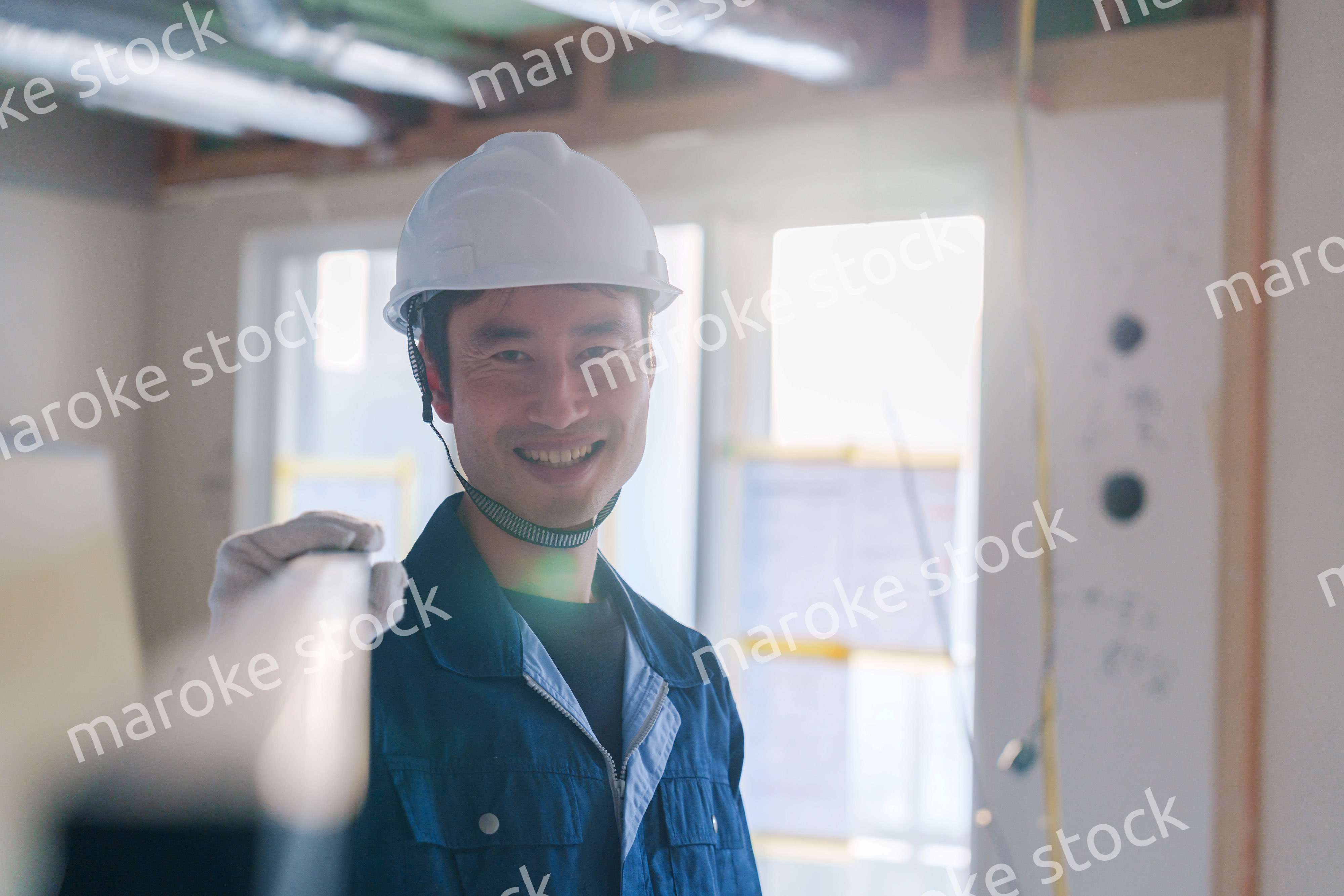 建設現場で資材を運ぶ男性の職人