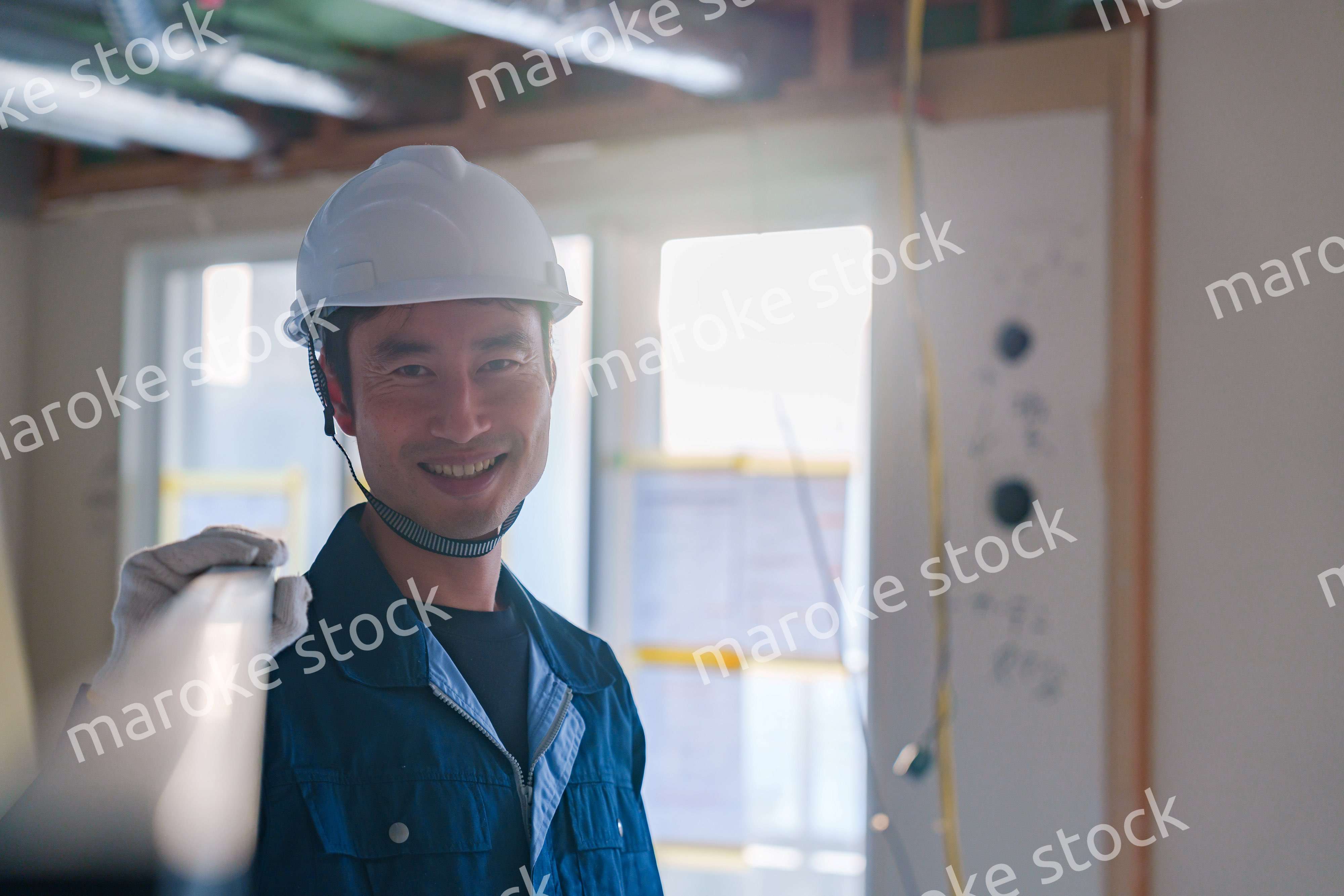 建設現場で資材を運ぶ男性の職人