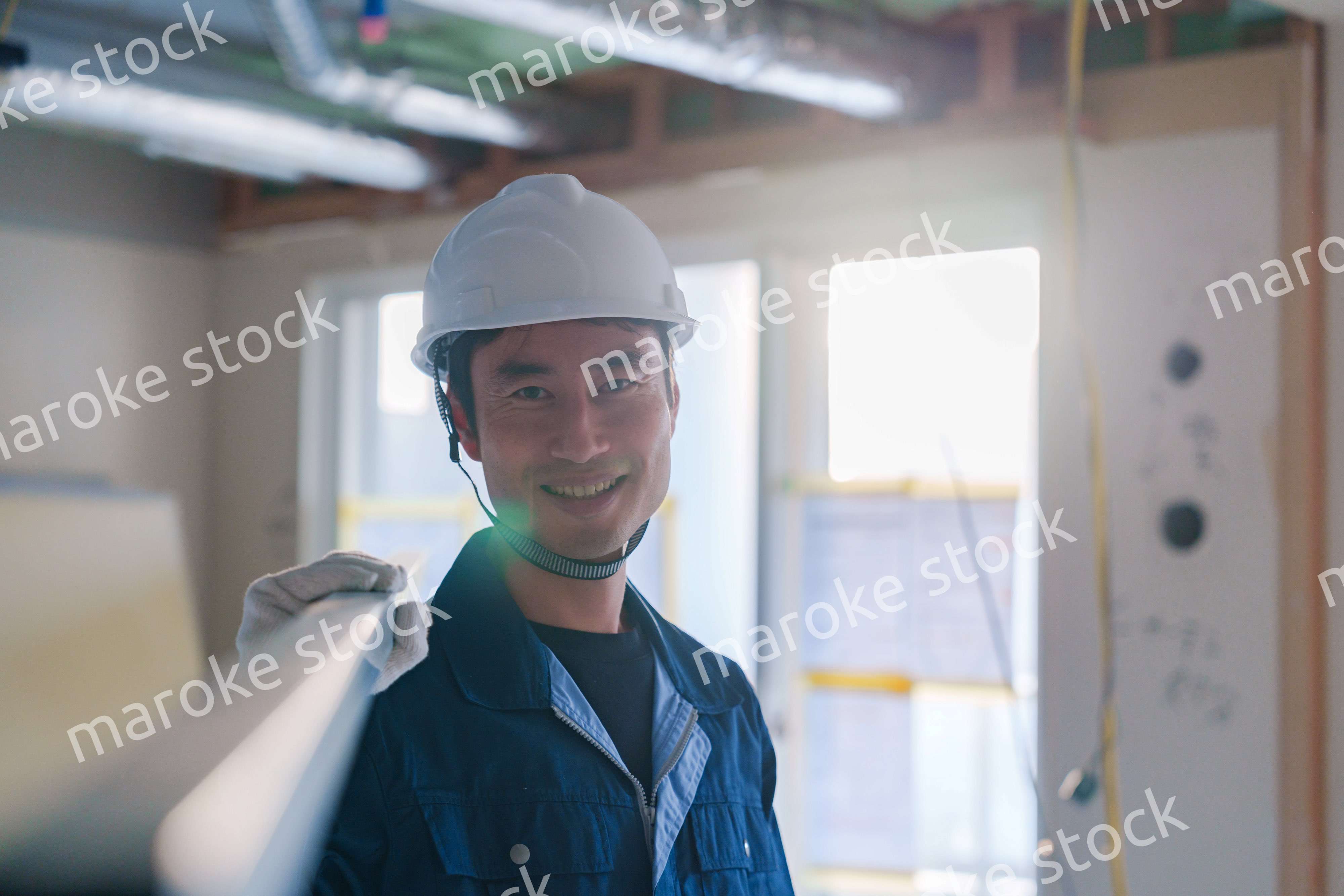 建設現場で資材を運ぶ男性の職人