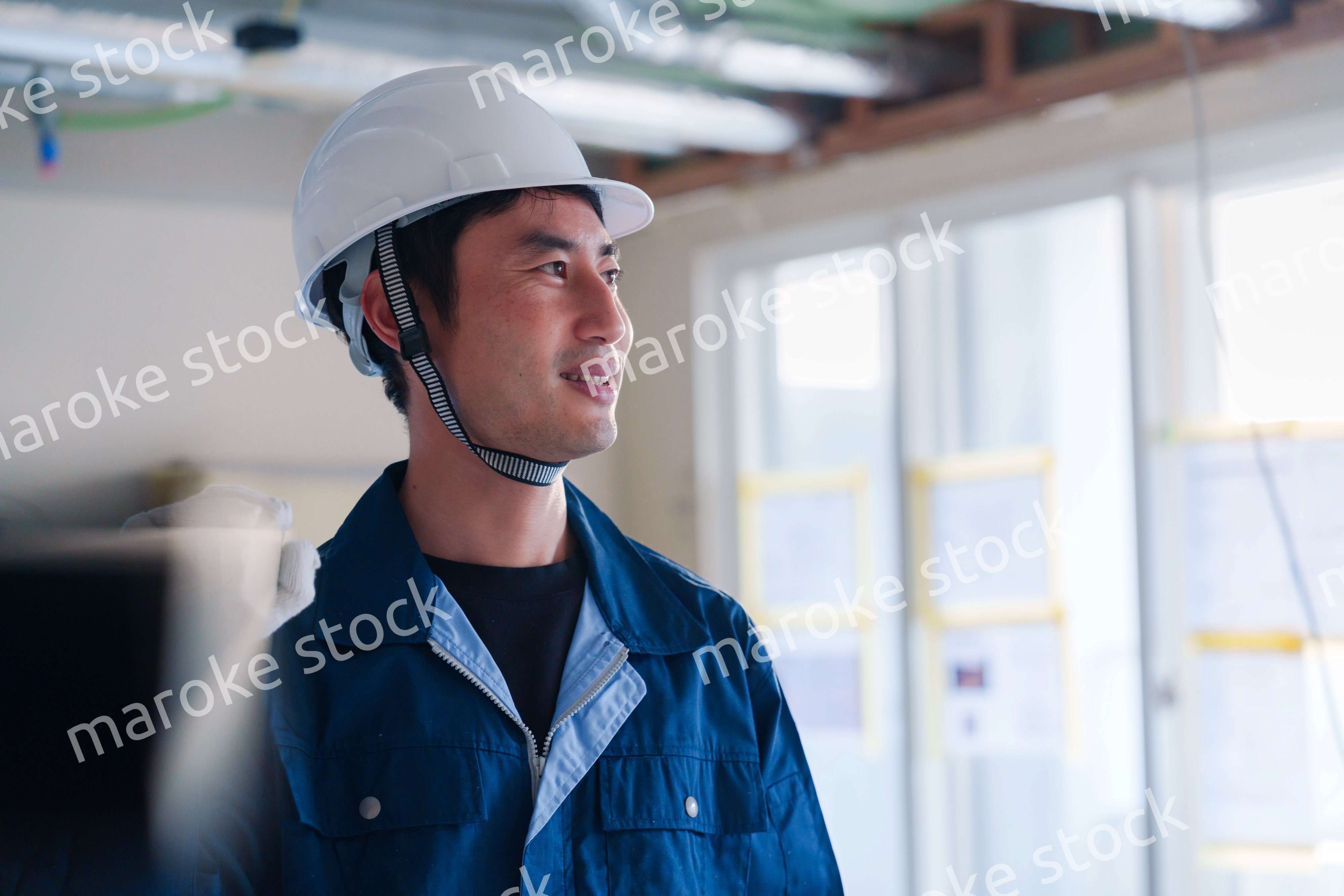 建設現場で資材を運ぶ男性の職人