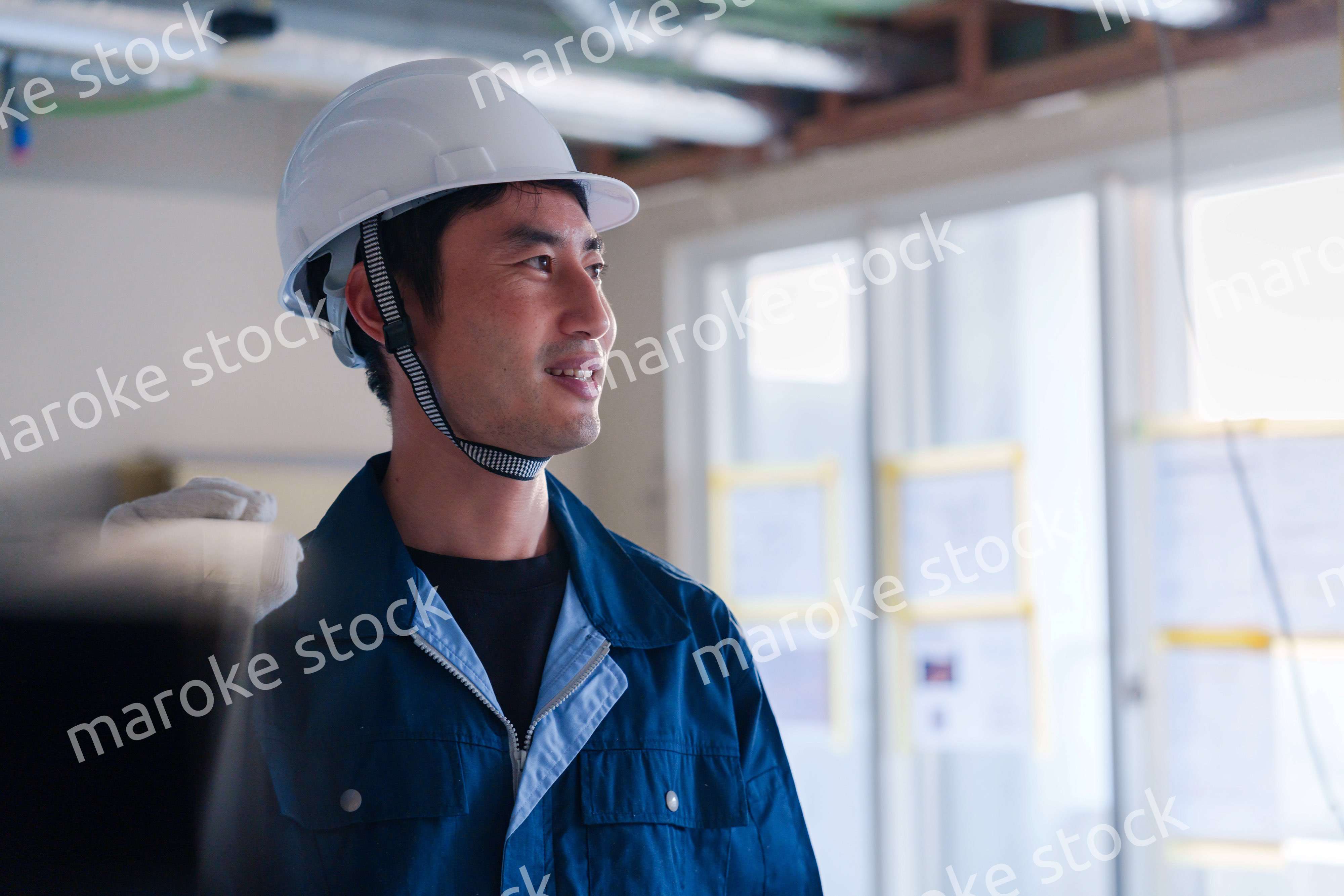 建設現場で資材を運ぶ男性の職人