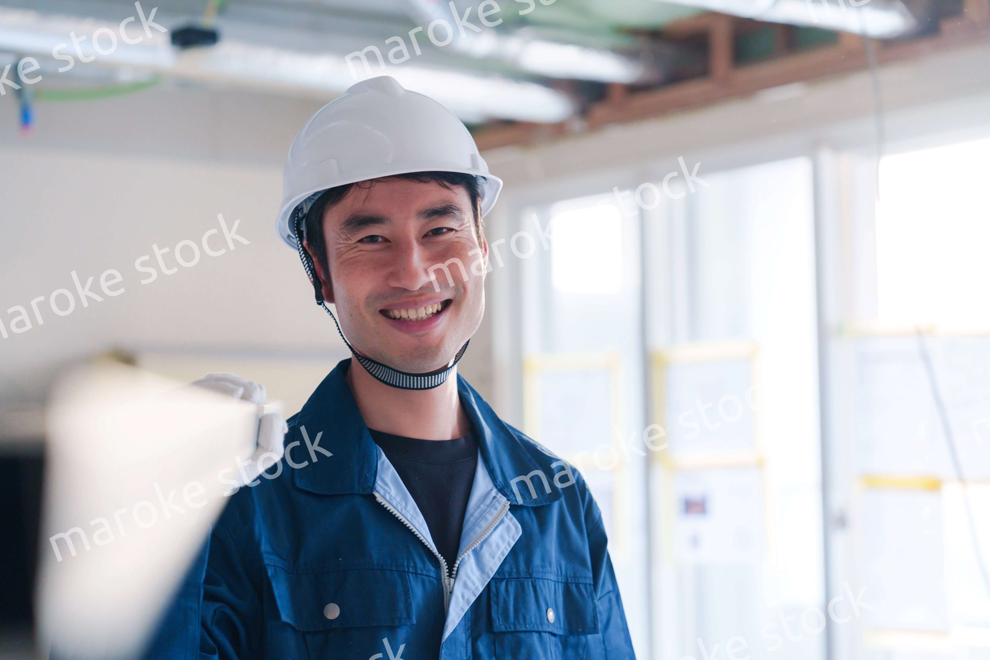 建設現場で資材を運ぶ男性の職人