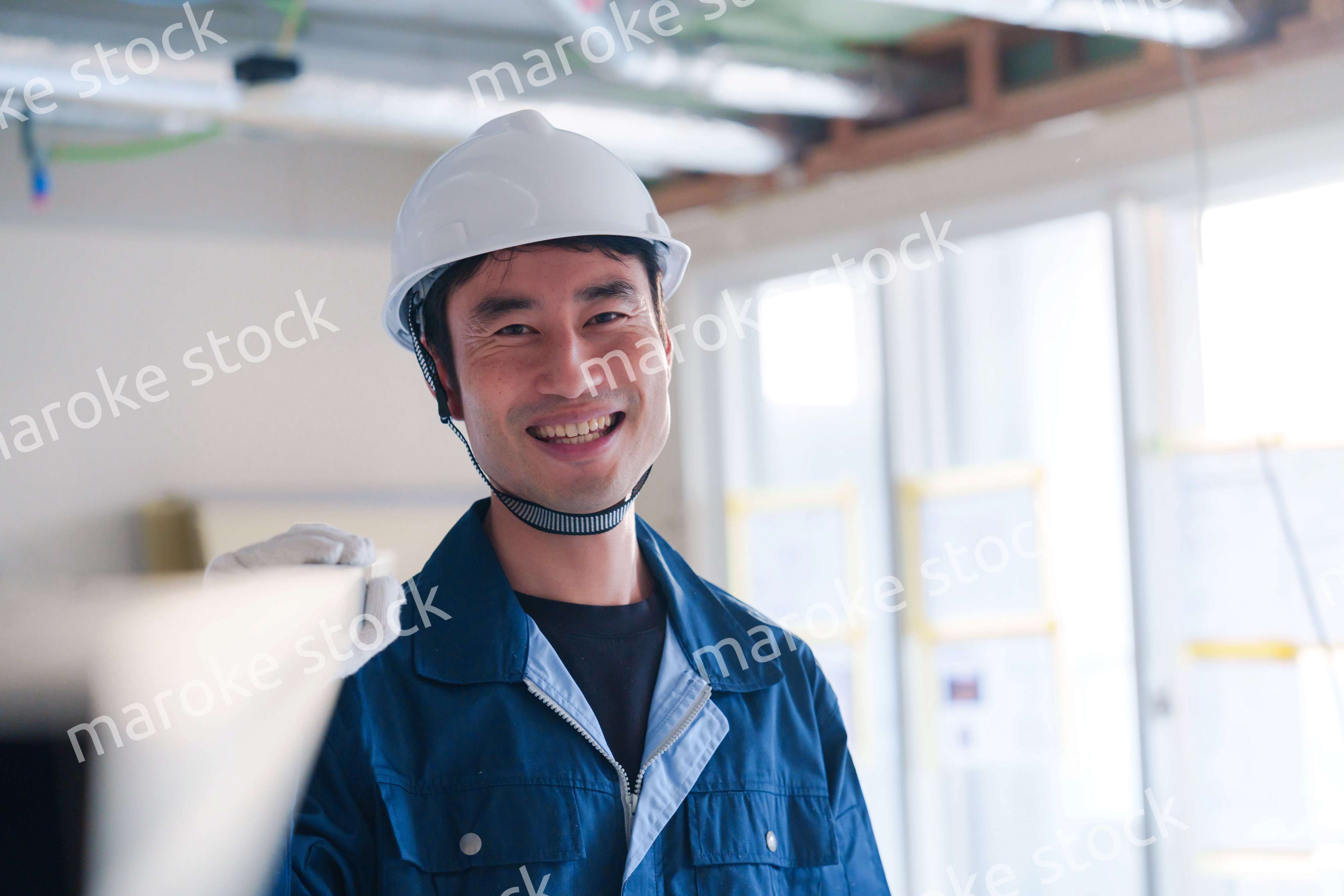 建設現場で資材を運ぶ男性の職人