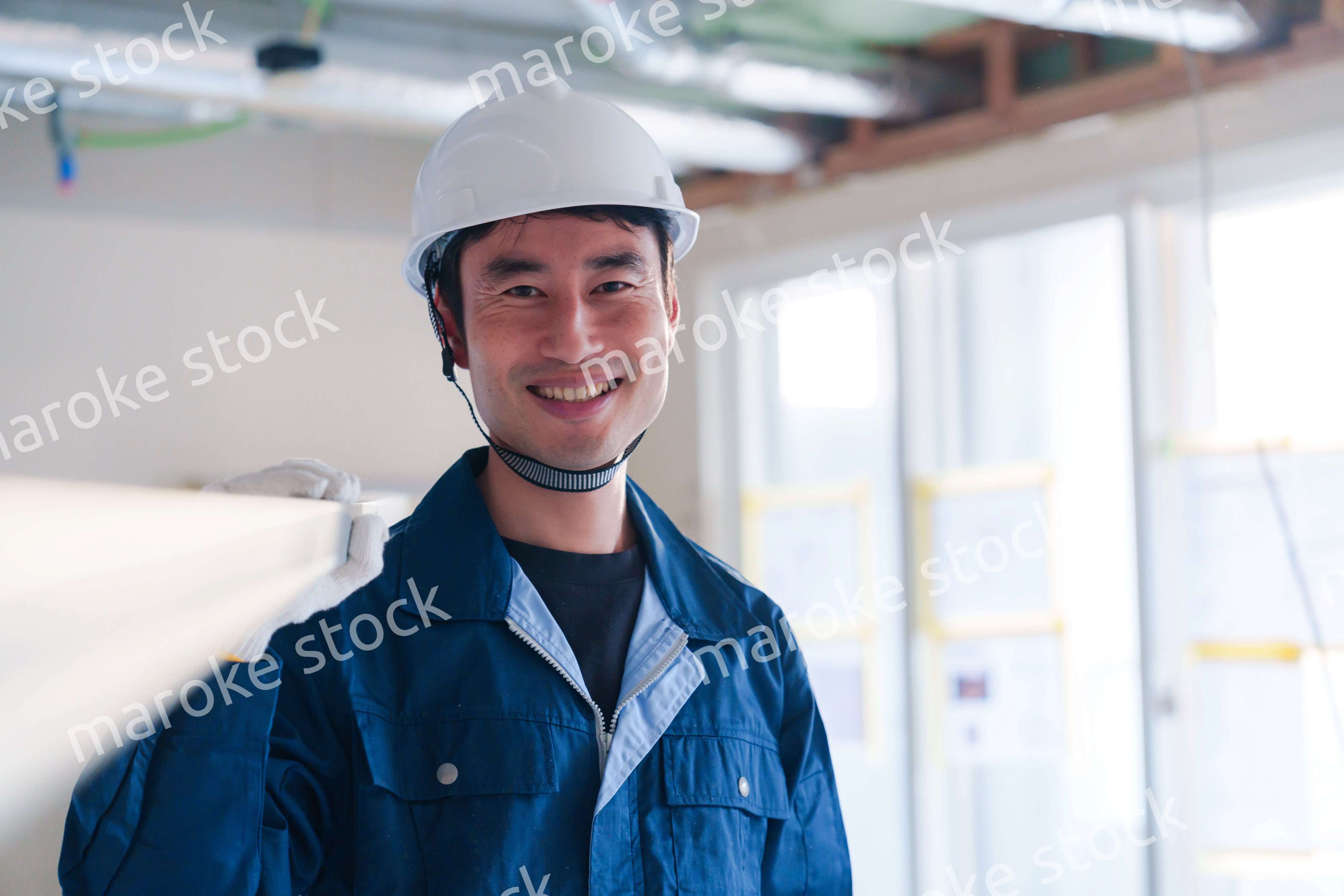 建設現場で資材を運ぶ男性の職人
