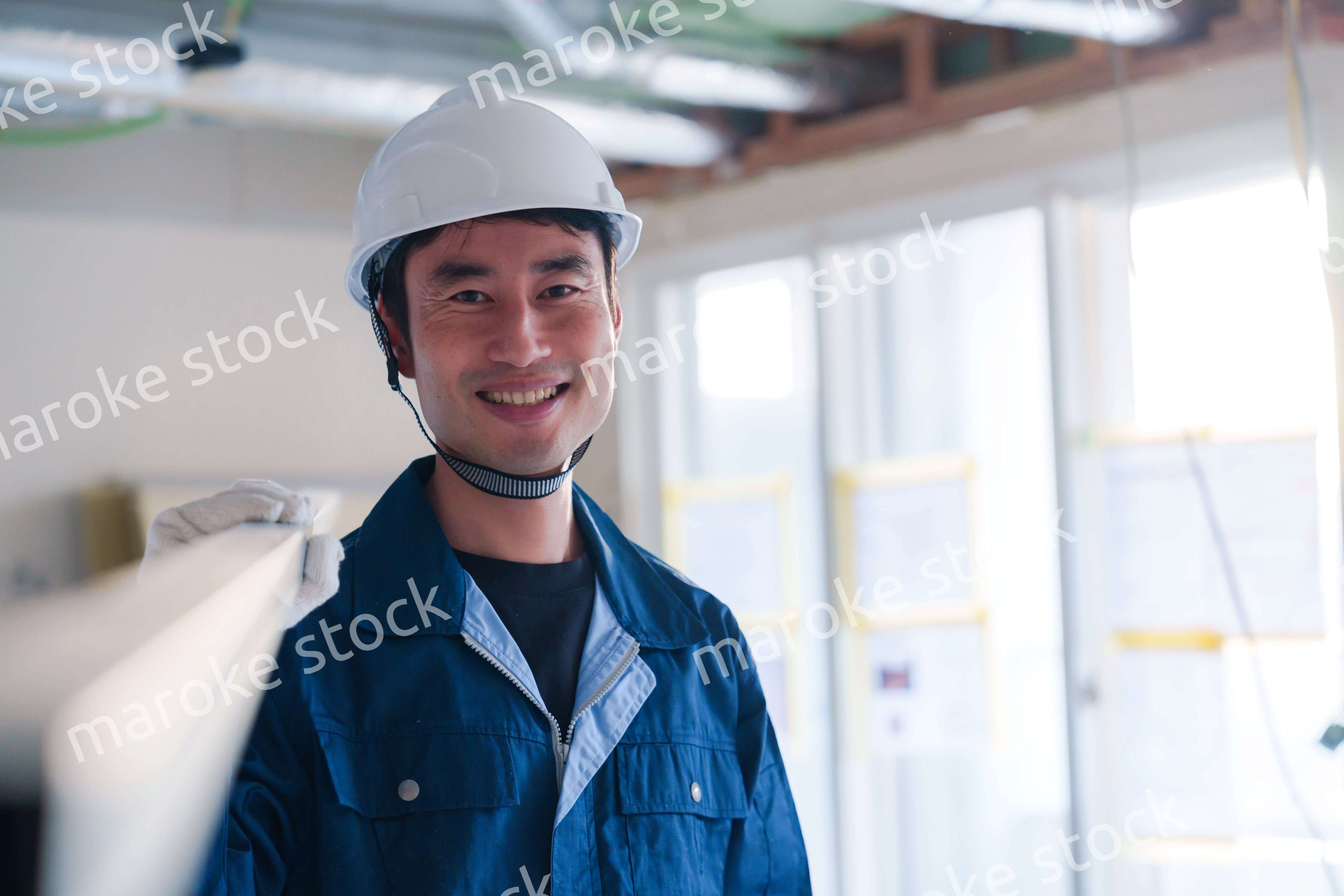 建設現場で資材を運ぶ男性の職人