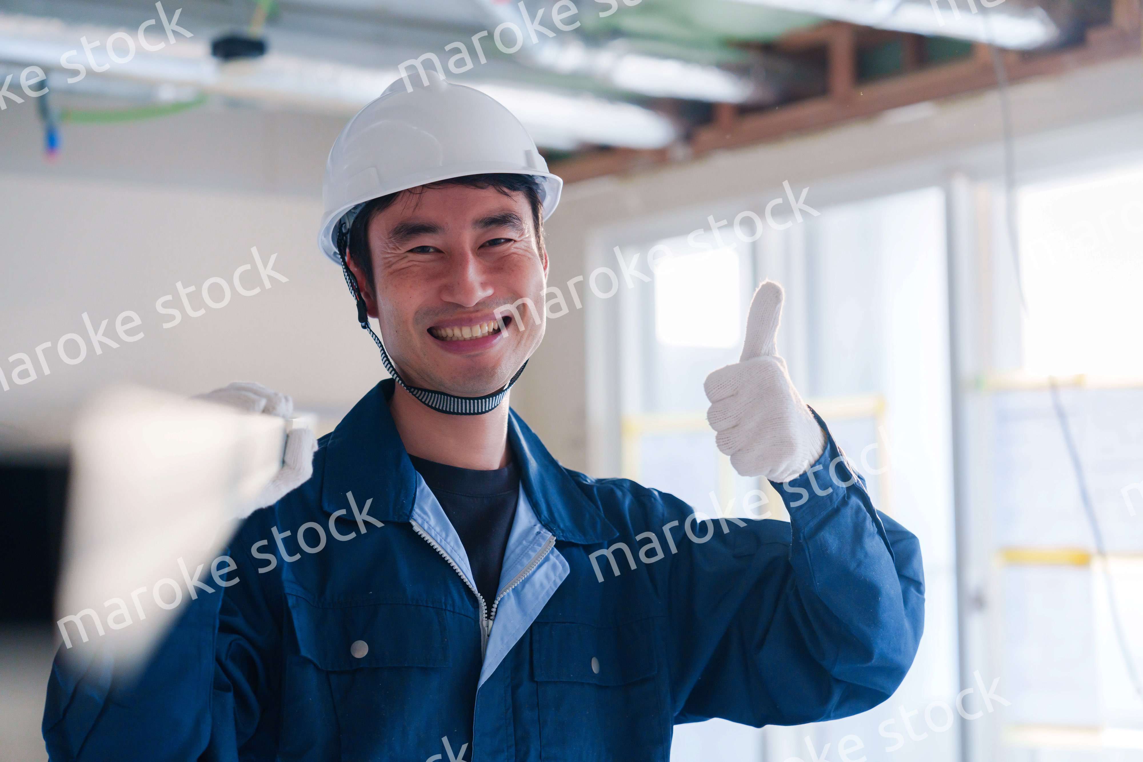 建設現場で資材を運ぶ男性の職人