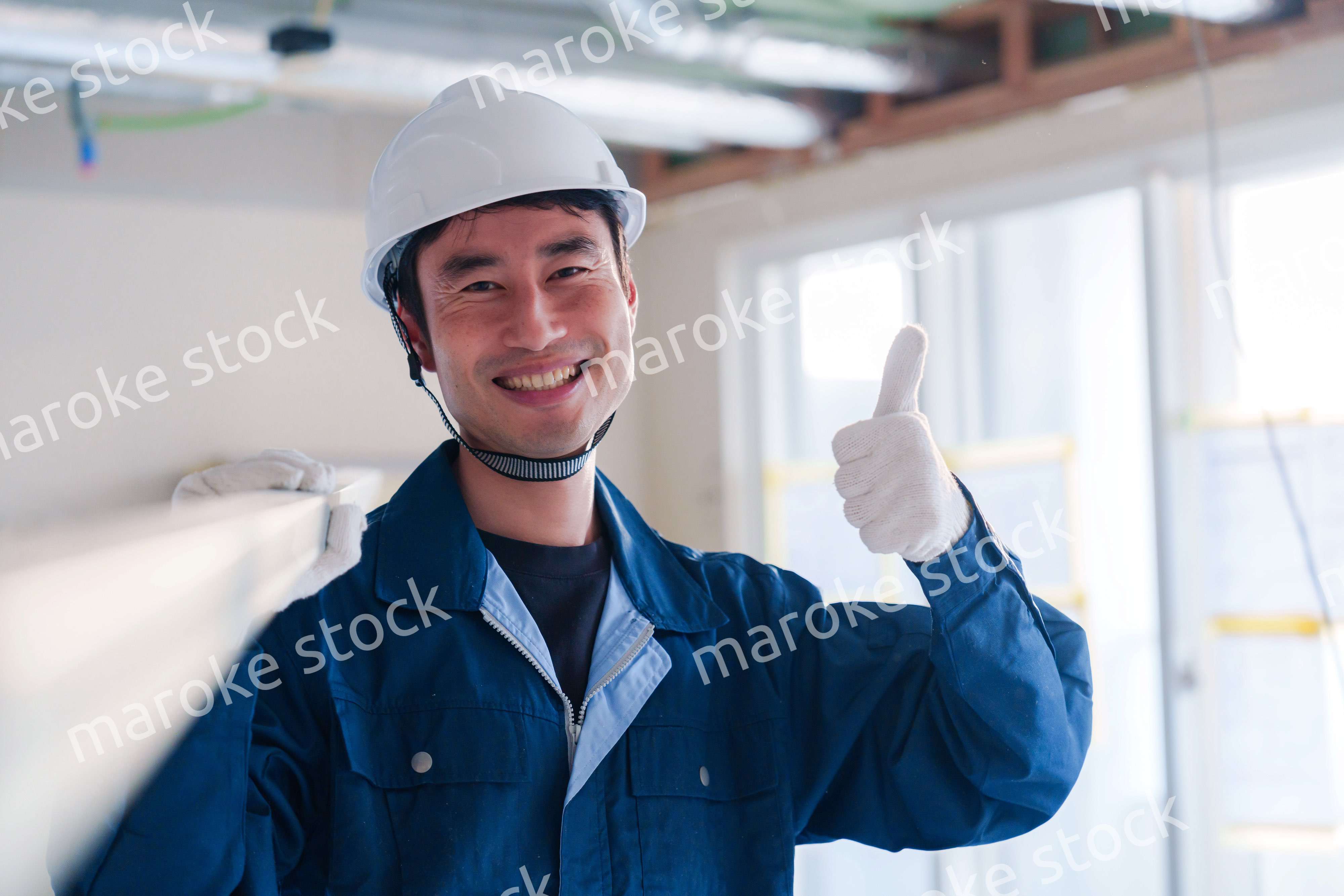 建設現場で資材を運ぶ男性の職人