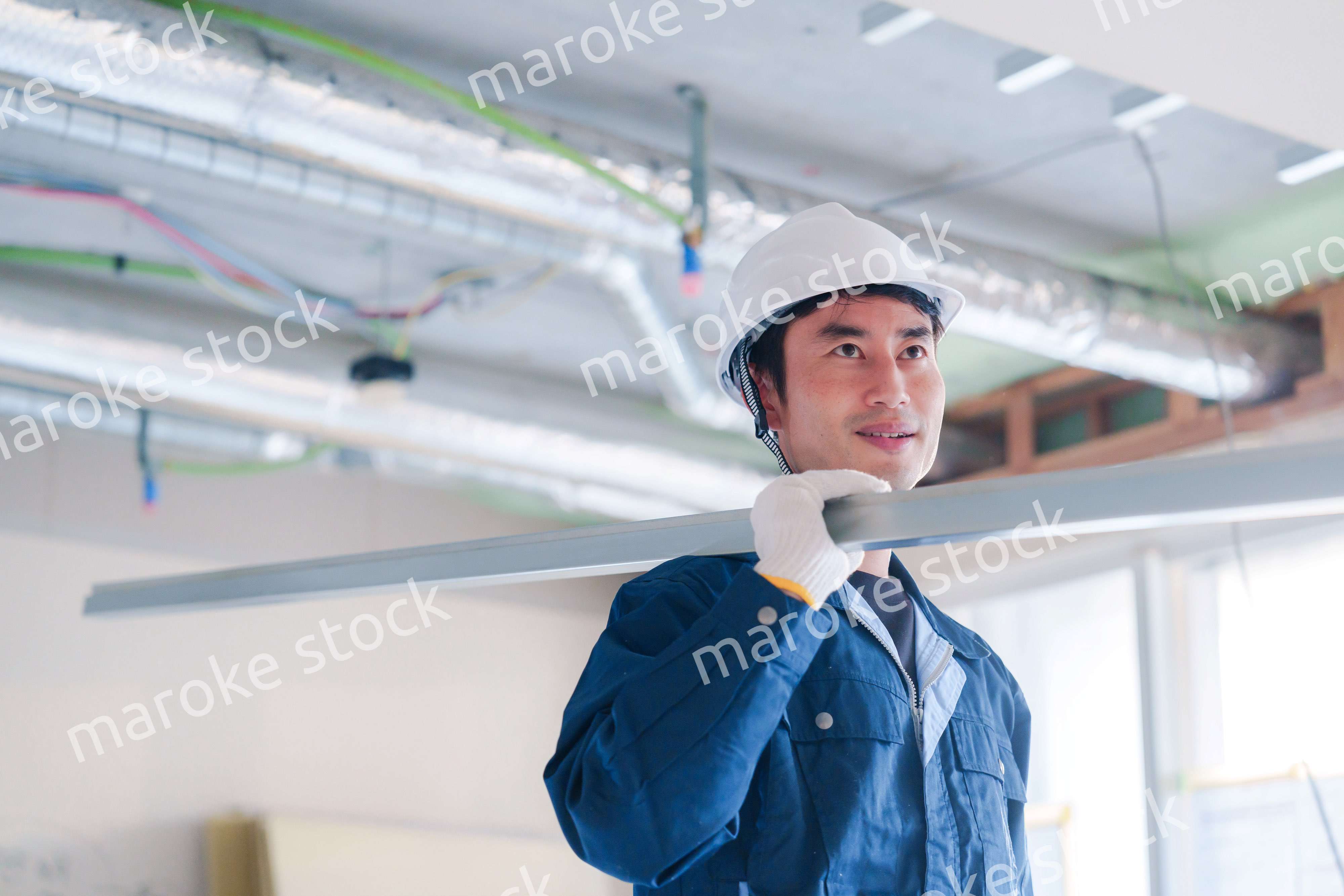 建設現場で資材を運ぶ男性の職人