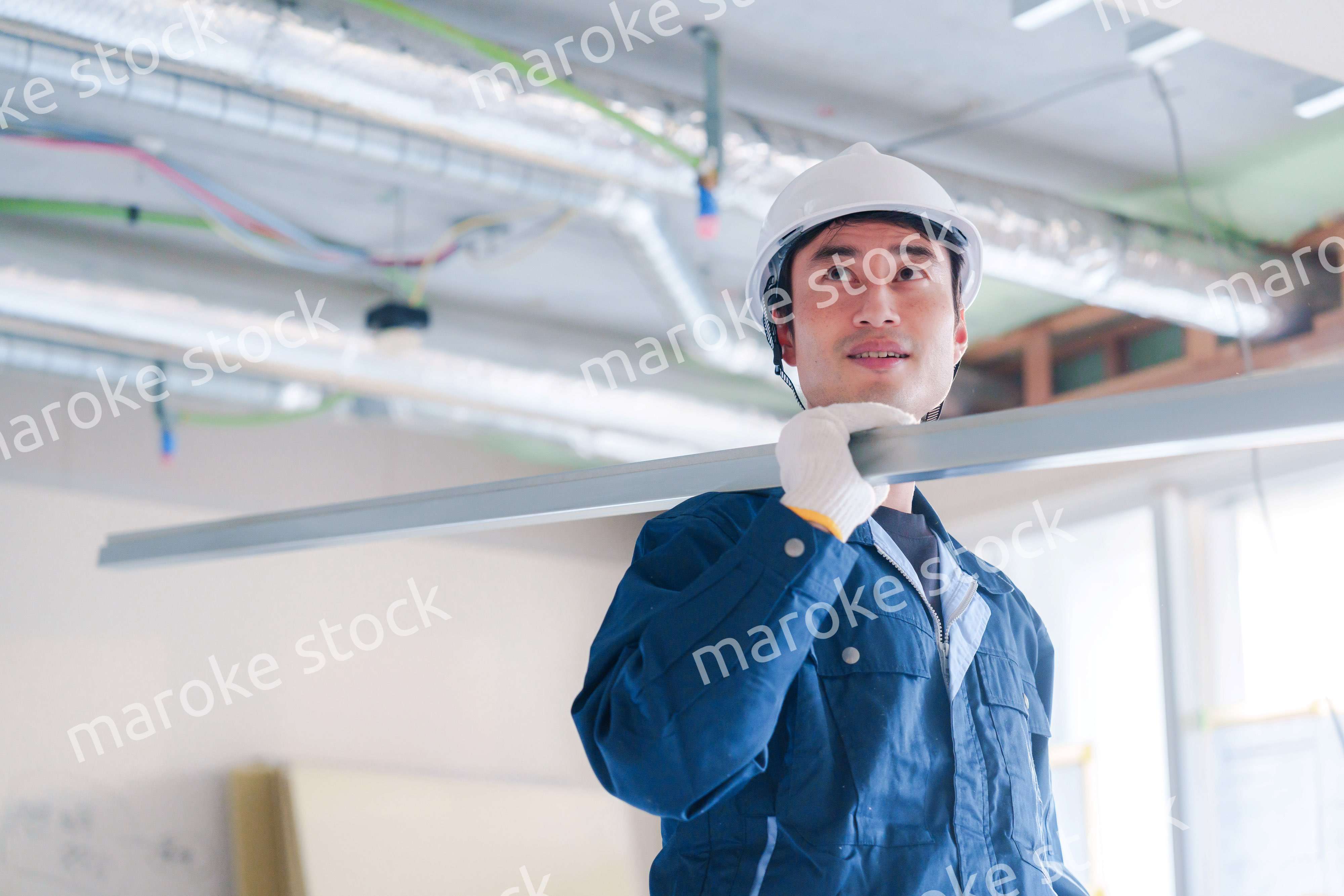 建設現場で資材を運ぶ男性の職人