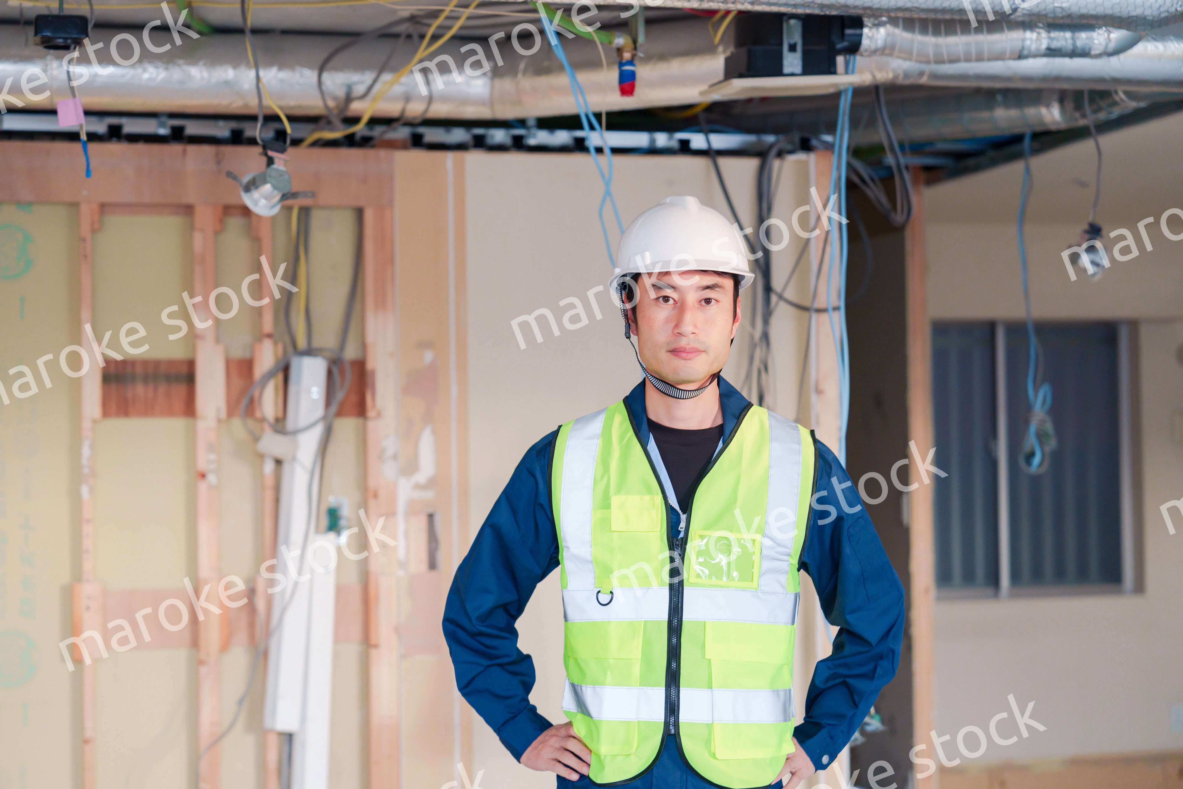 工事現場で安全服を着て作業をする男性大工