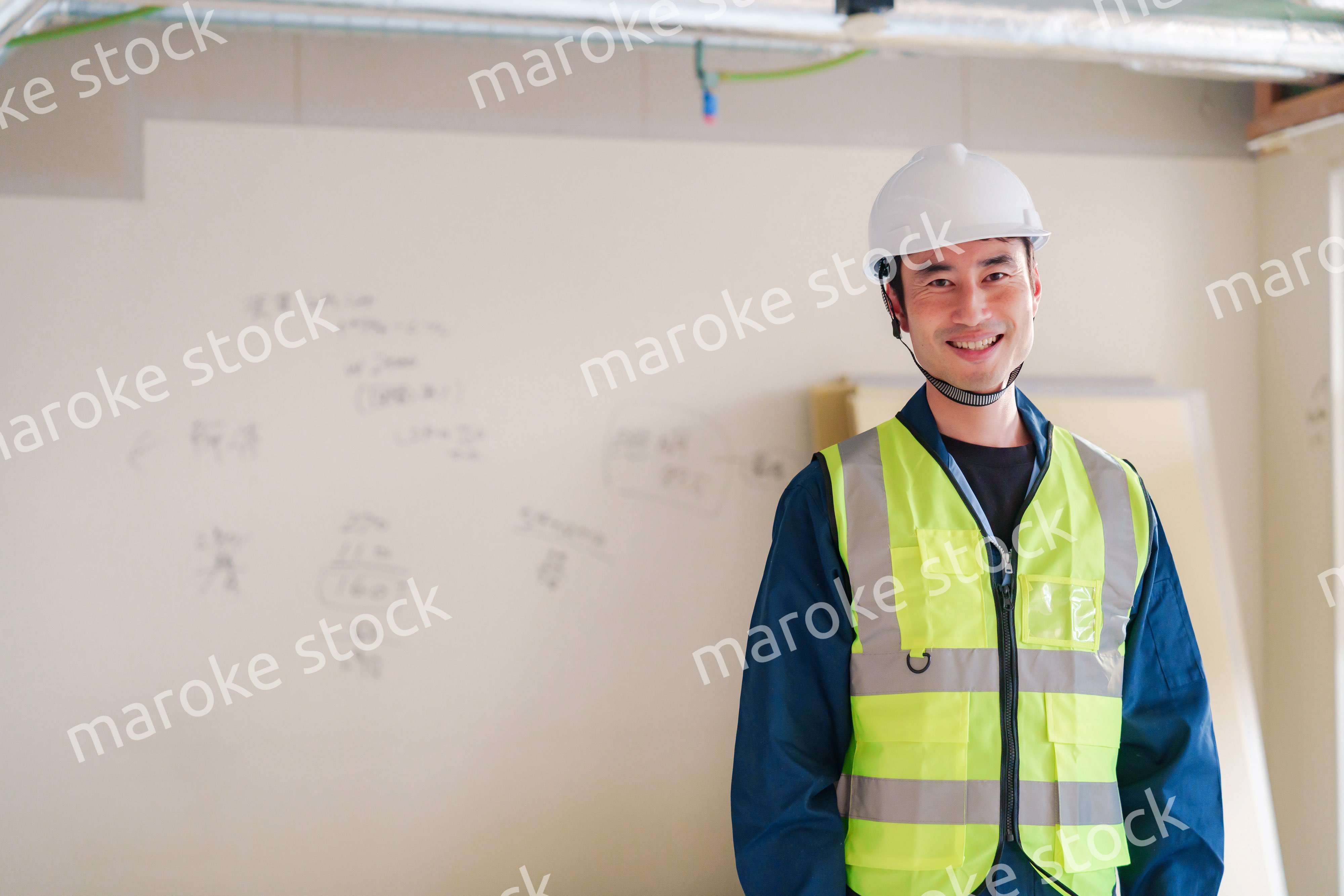 工事現場で安全服を着て作業をする男性大工