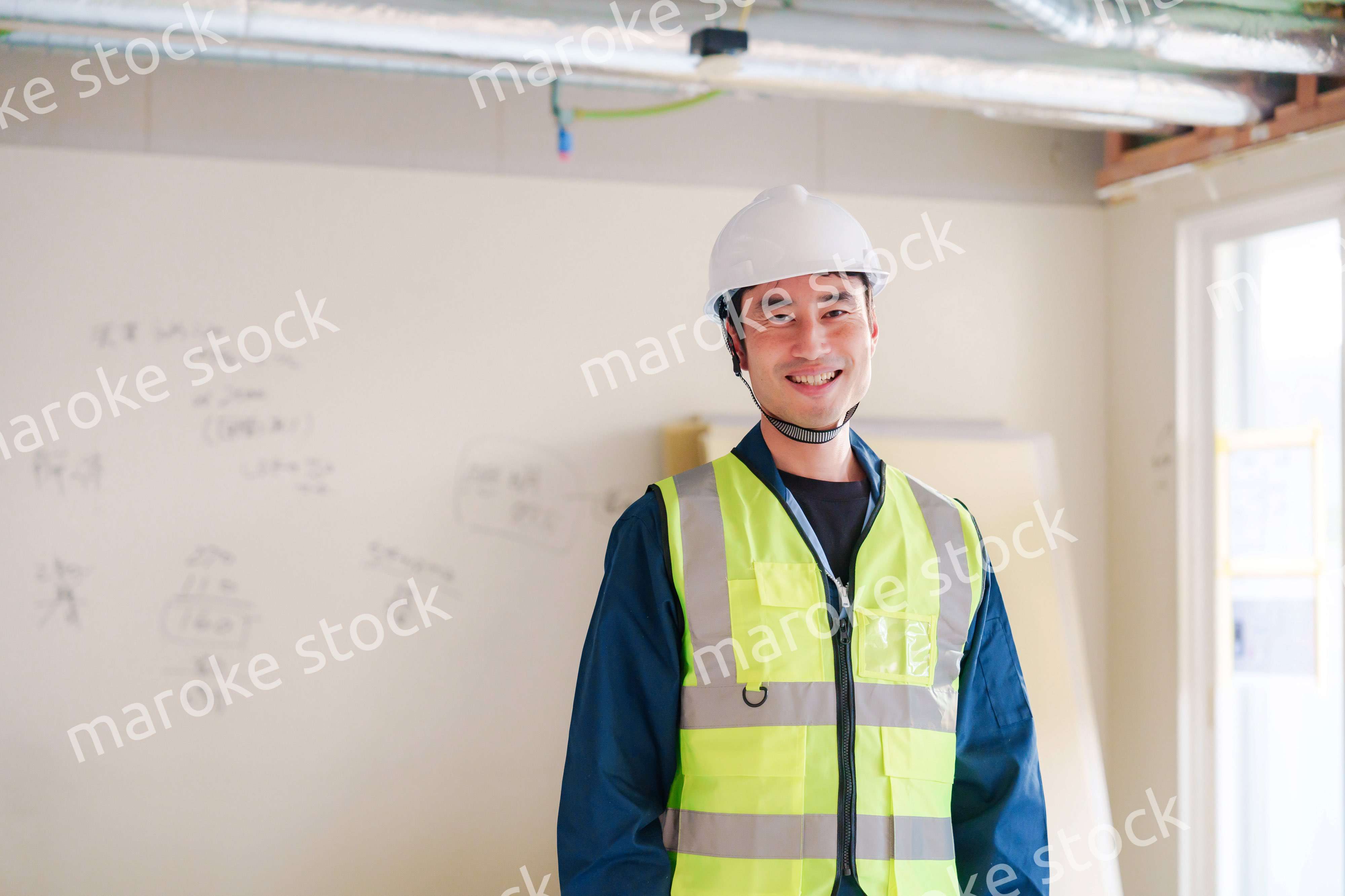 工事現場で安全服を着て作業をする男性大工