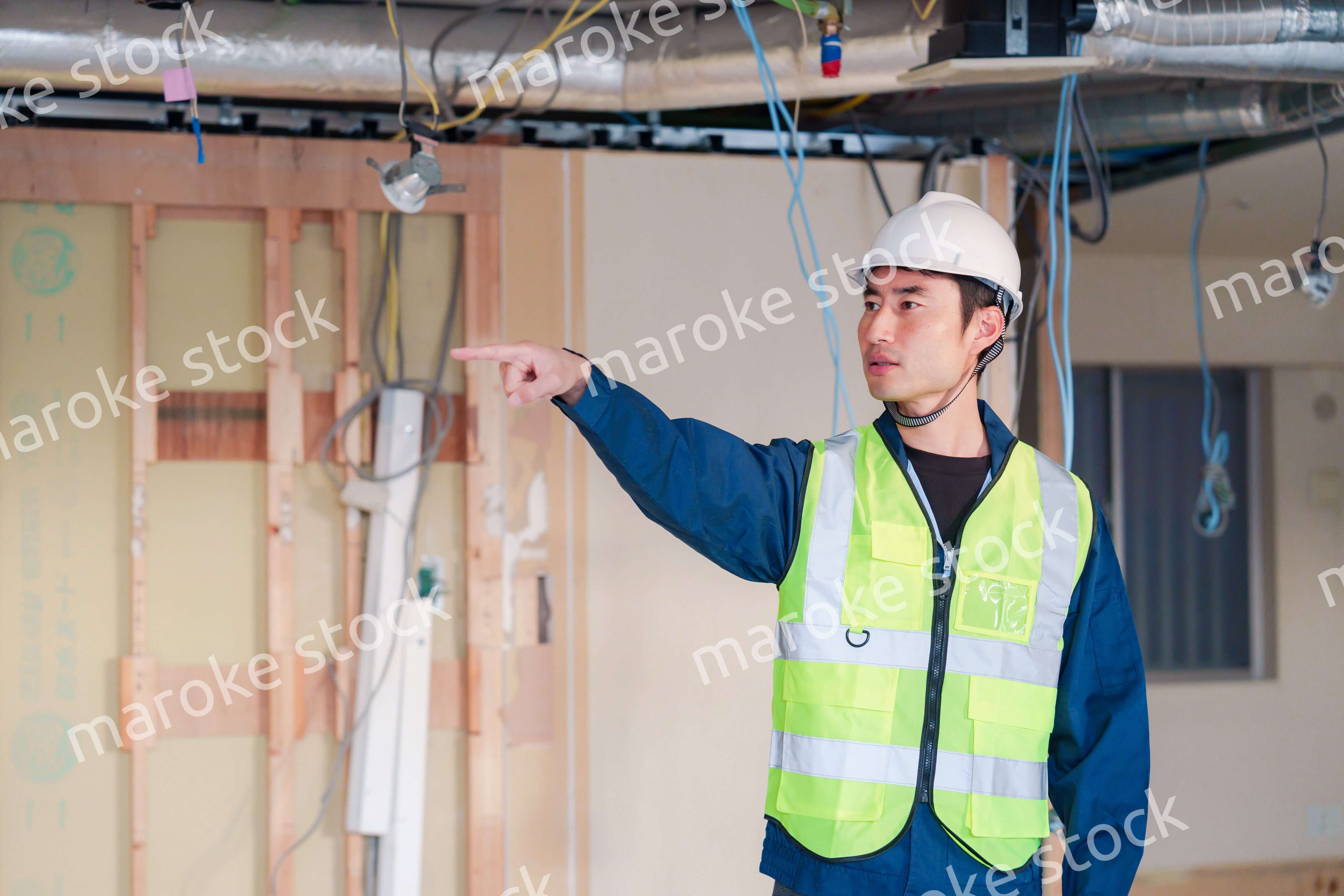 工事現場で安全服を着て作業をする男性大工