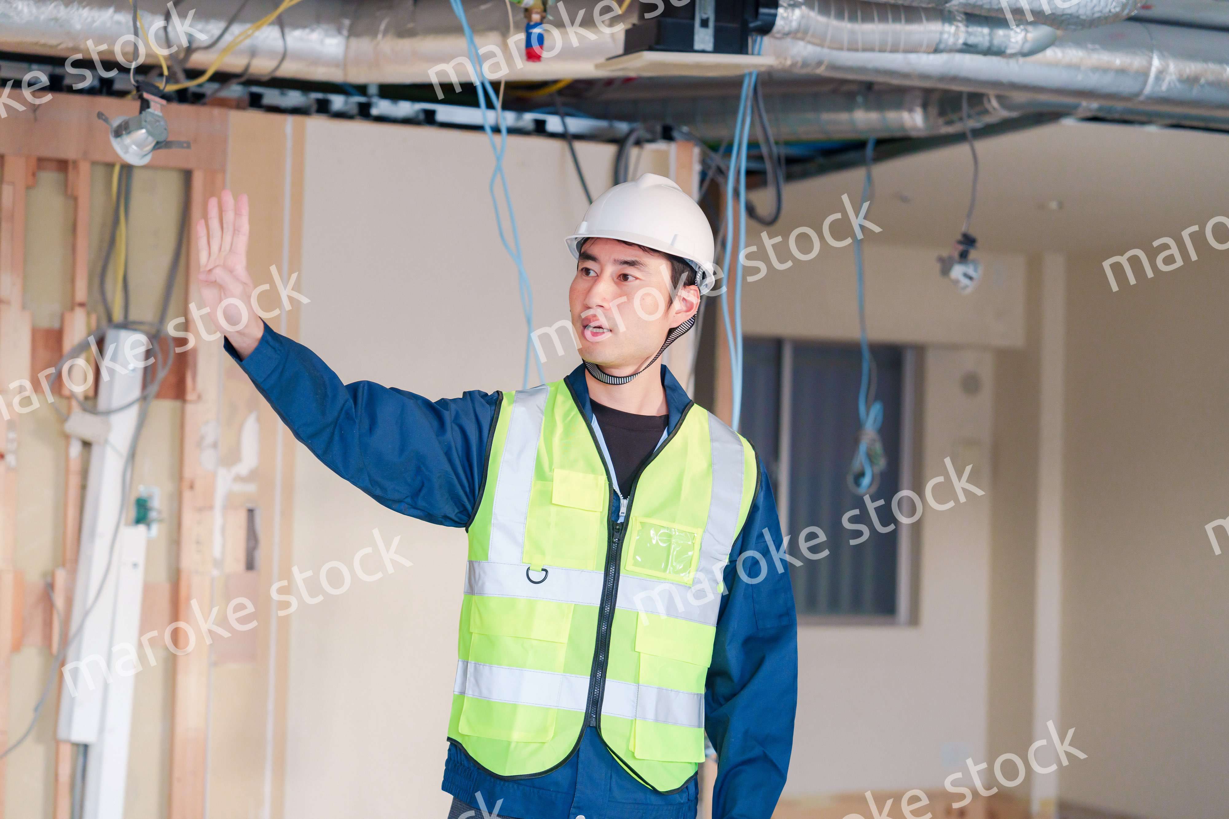 工事現場で安全服を着て作業をする男性大工