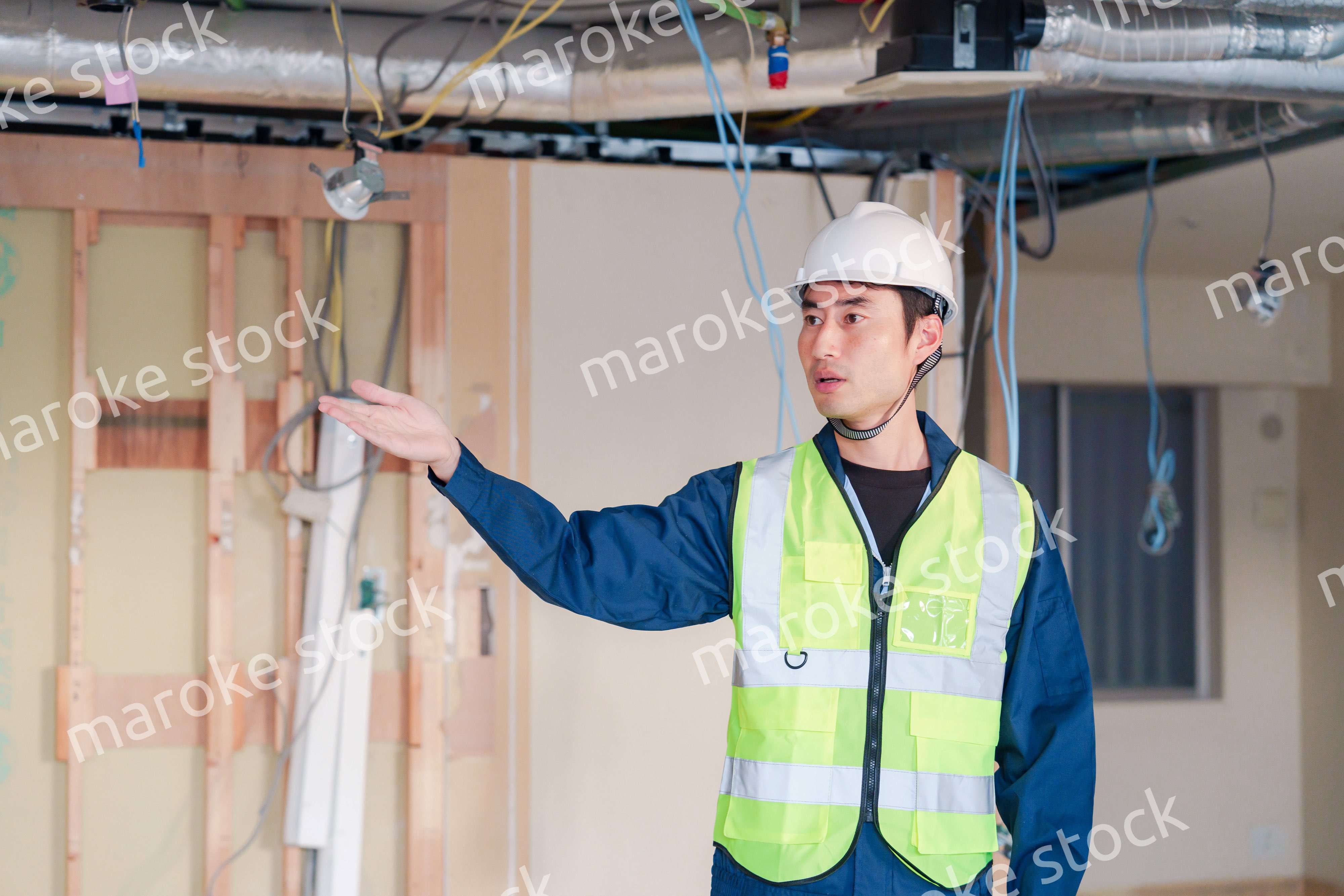 工事現場で安全服を着て作業をする男性大工