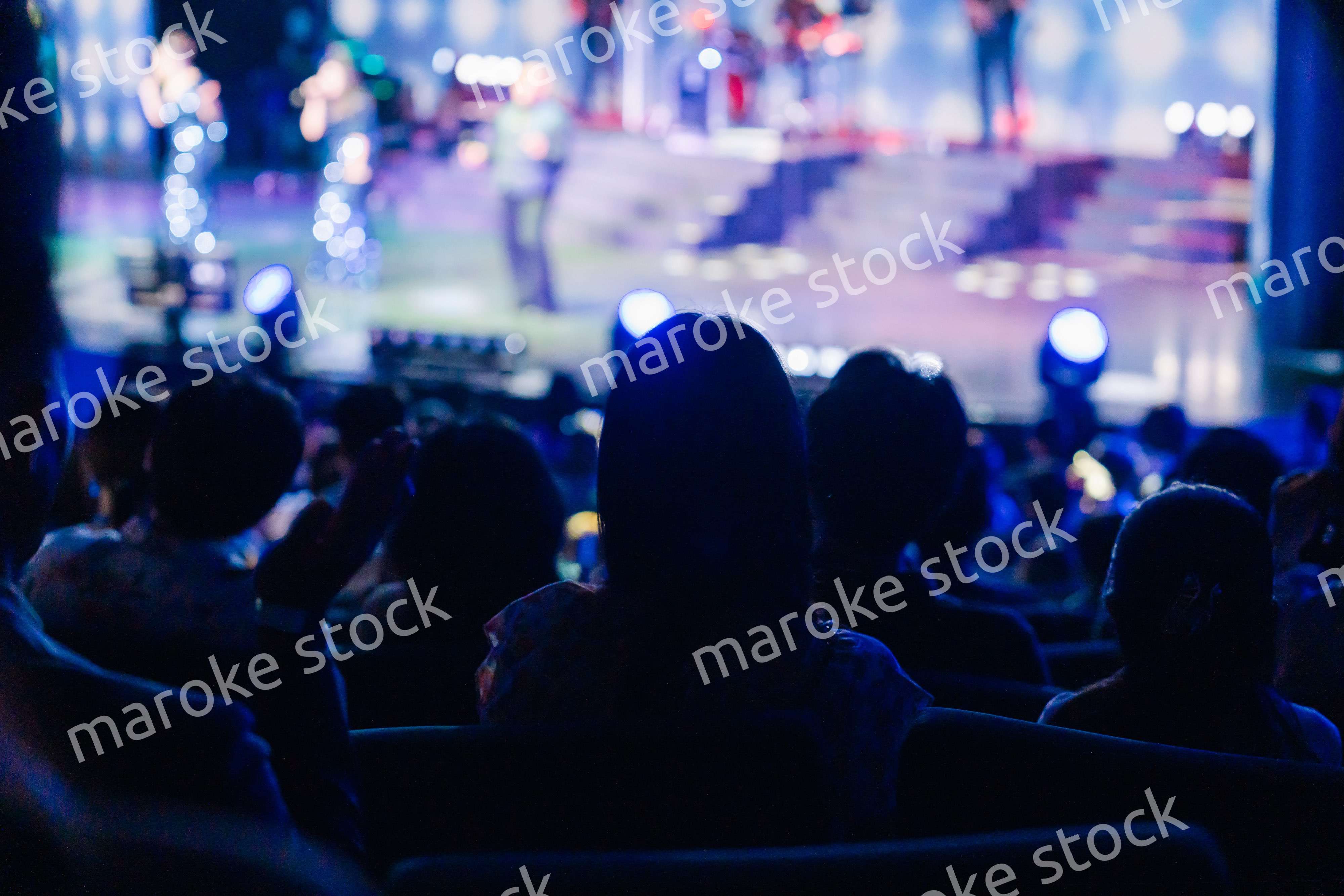 ホールでライブパフォーマンスを鑑賞する客